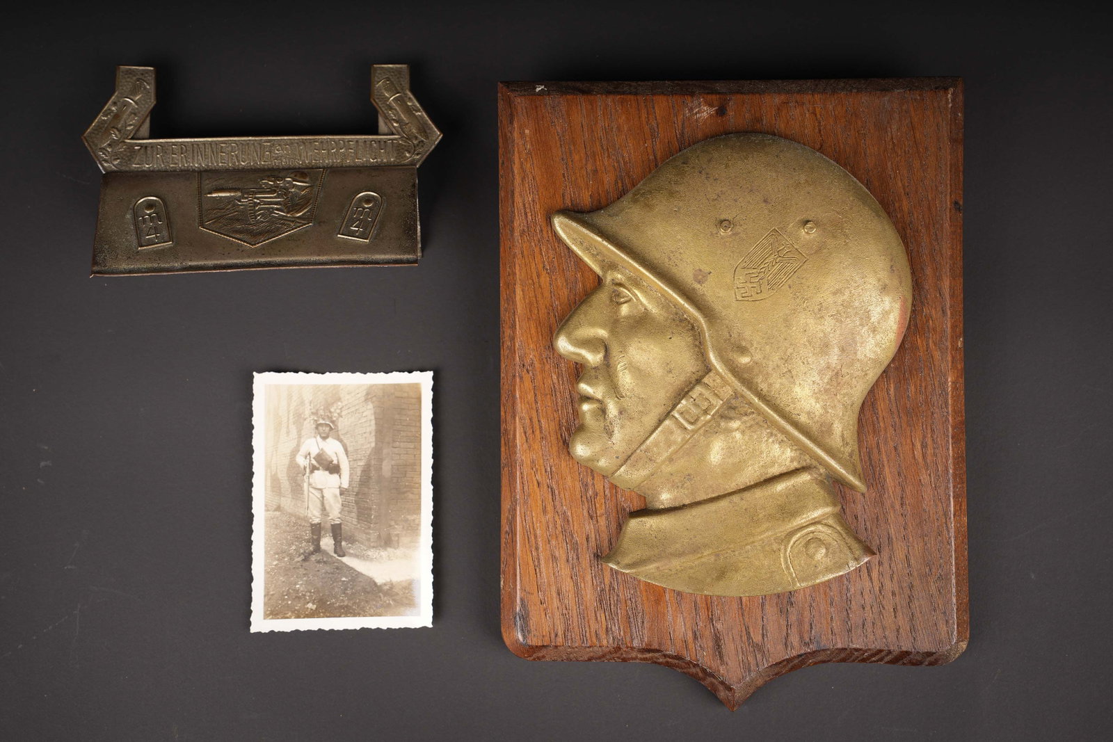 Souvenirs de service militaire Heer et Maschinengewehr Abteilung. Heer and Maschinengewehr-Abteilung: Souvenirs de service militaire Heer et Maschinengewehr Abteilung. Un ecu en bois avec en applique le profil d un soldat allemand casque en metal dore. Dimensions approximatives 21,5 x 15,5 cm. Un