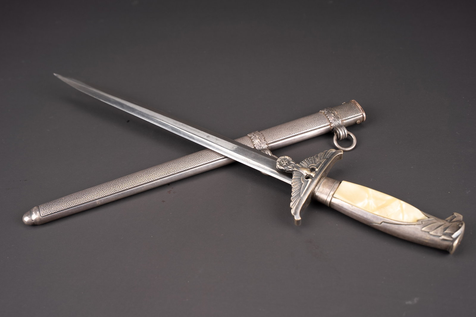 Dague Gouvernementale. Government Dagger.: Dague gouvernementale. Garniture en metal, couleur argent. Plaquettes completes. Tete tournee a gauche. Garde disposant d un aigle aux ailes deployees. Belle lame, fabrication Alcoso. Fourreau complet