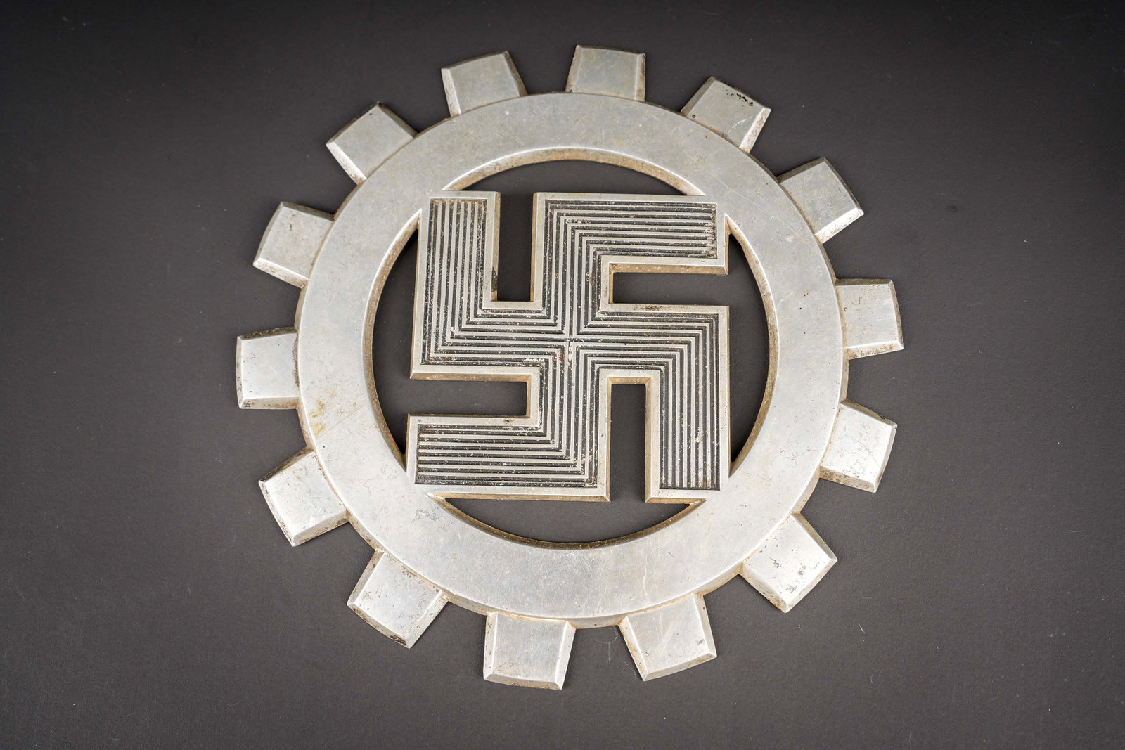 Insigne mural du DAF. DAF wall plaque.: Insigne mural du DAF. En metal, reste de peinture noire au niveau de l insigne national. Sans marquages visibles. Diametre 20 cm. A noter une certaine usure et patine de la piece. Etat II+. DAF wall
