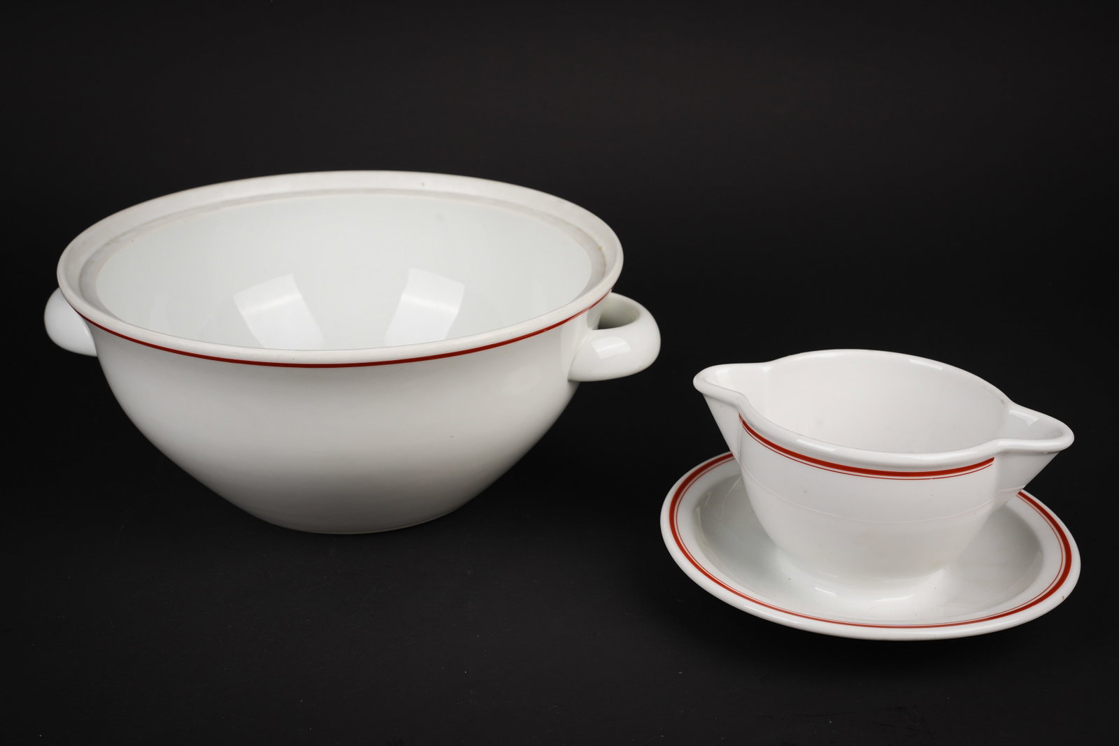 Vaisselle du DAF. DAF tableware.: Vaisselle du DAF. Comprenant un saladier en ceramique blanche. Lisere rouge. Deux poignees de transport, couvercle absent. Bel insigne du DAF, fabrication Rosenthal. Diametre 26,5 cm, hauteur 12 cm.