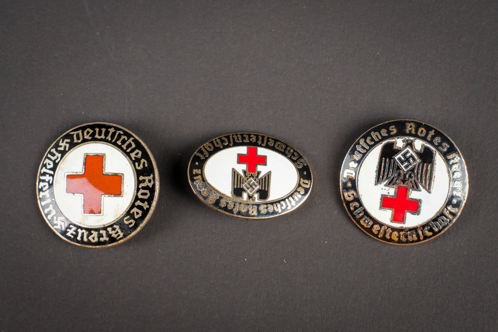 Insignes DRK. German Red Cross insignias.: Insignes DRK. Comprenant un insigne en metal emaille marque Deutsches Rotes Kreuz Helferin, attache complete, fabrication ELM. Un insigne en metal emaille de forme ovale, marquages Deutsches Rotes