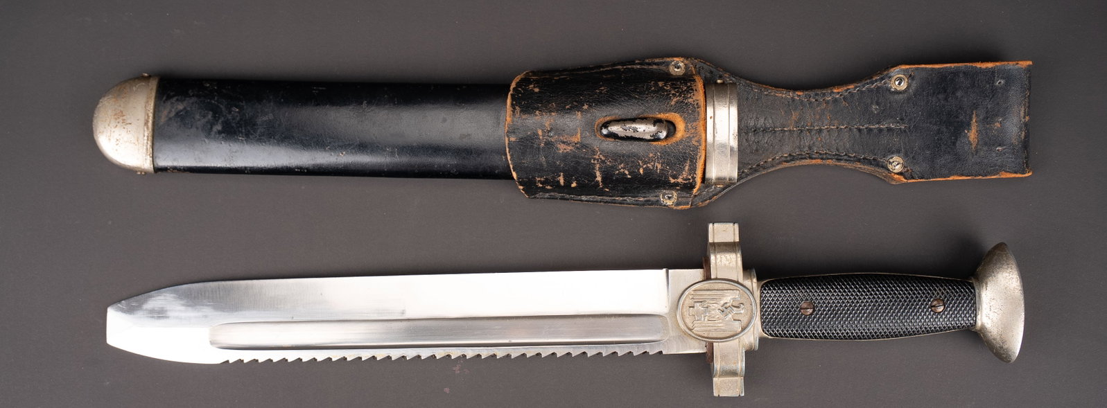 Fendoir DRK. German Red cross Dagger.: Fendoir DRK. Garniture en metal nickele. Une plaquette en bakelite striee et une seconde lisse. Belle lame tournevis a dent de scie, sans marquages visibles. Fourreau en metal. Peinture noire a 80%.