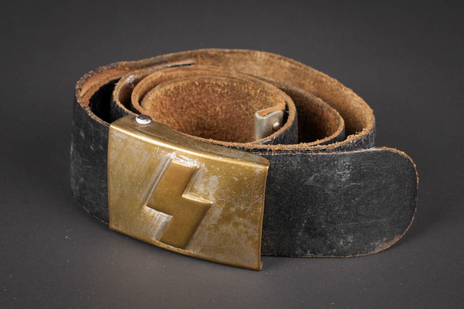 Ceinturon Deutsche Jungvolk. Hitler Youth belt.: Ceinturon Deutsche Jungvolk. Ceinturon en cuir marron. Bouclerie en metal. Patte de reglage complete. Boucle de ceinturon DJ en metal, rune de couleur doree. Fabrication HK 45. A noter une certaine