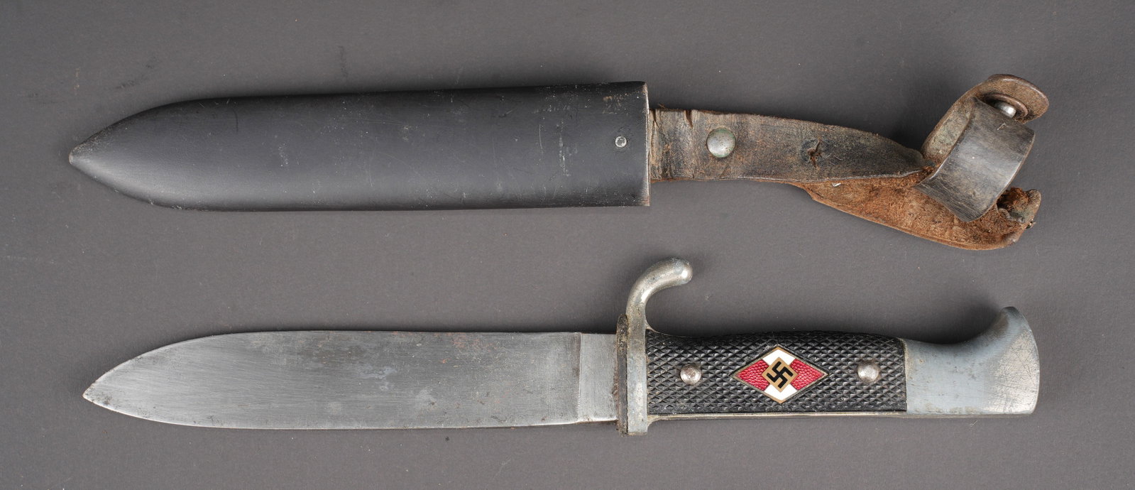 Couteau de marche HJ. Hitler Youth Dagger.: Couteau de marche de la Hitlerjugend. Garnitures en metal nickele. Plaquettes en bakelite noir. Insigne de la Hitlerjugend en metal emaille recolle. Lame en bon etat. Fabrication RZM M7/40. Fourreau