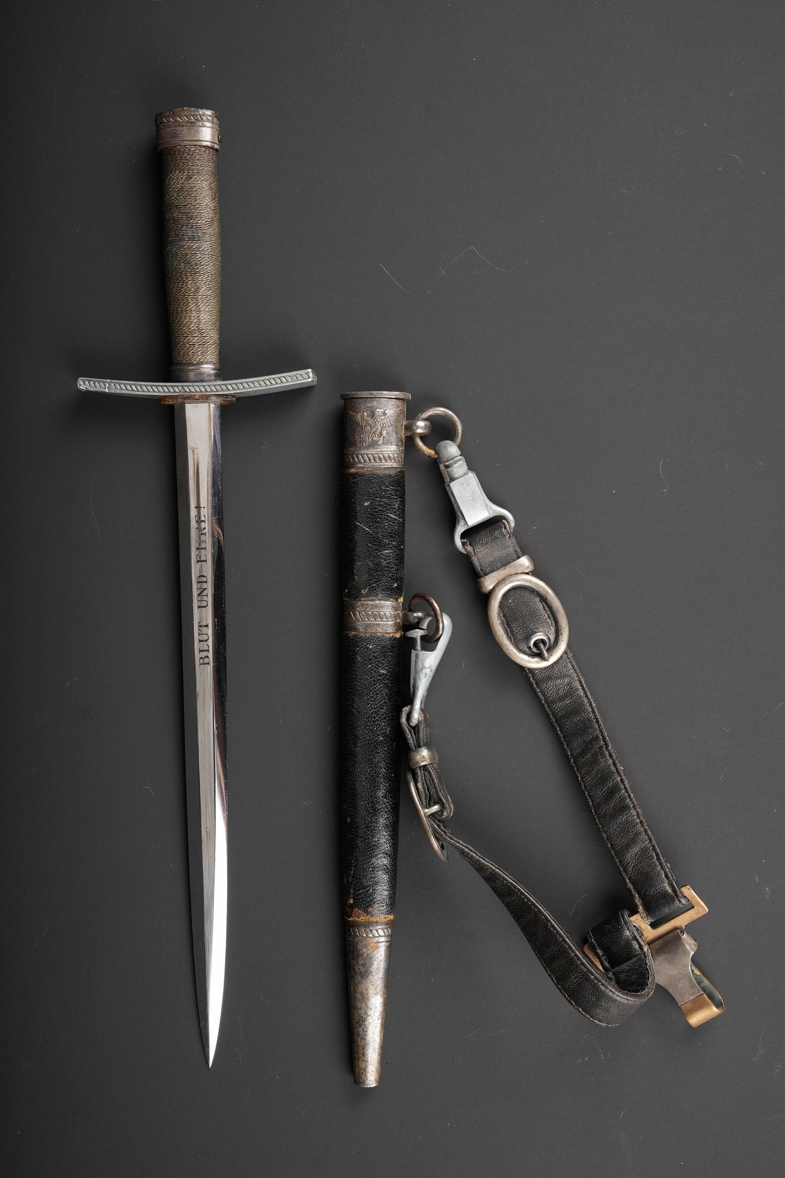 Dague de Chef HJ. Hitler Youth leader?s dagger.: Dague de Chef Hitlerjugend. Garnitures en metal. Pommeau disposant de l insigne Hitlerjugend. Belle garde en metal, legerement incurvee. Poignee composee d un filigrane couleur argent. Belle lame comp