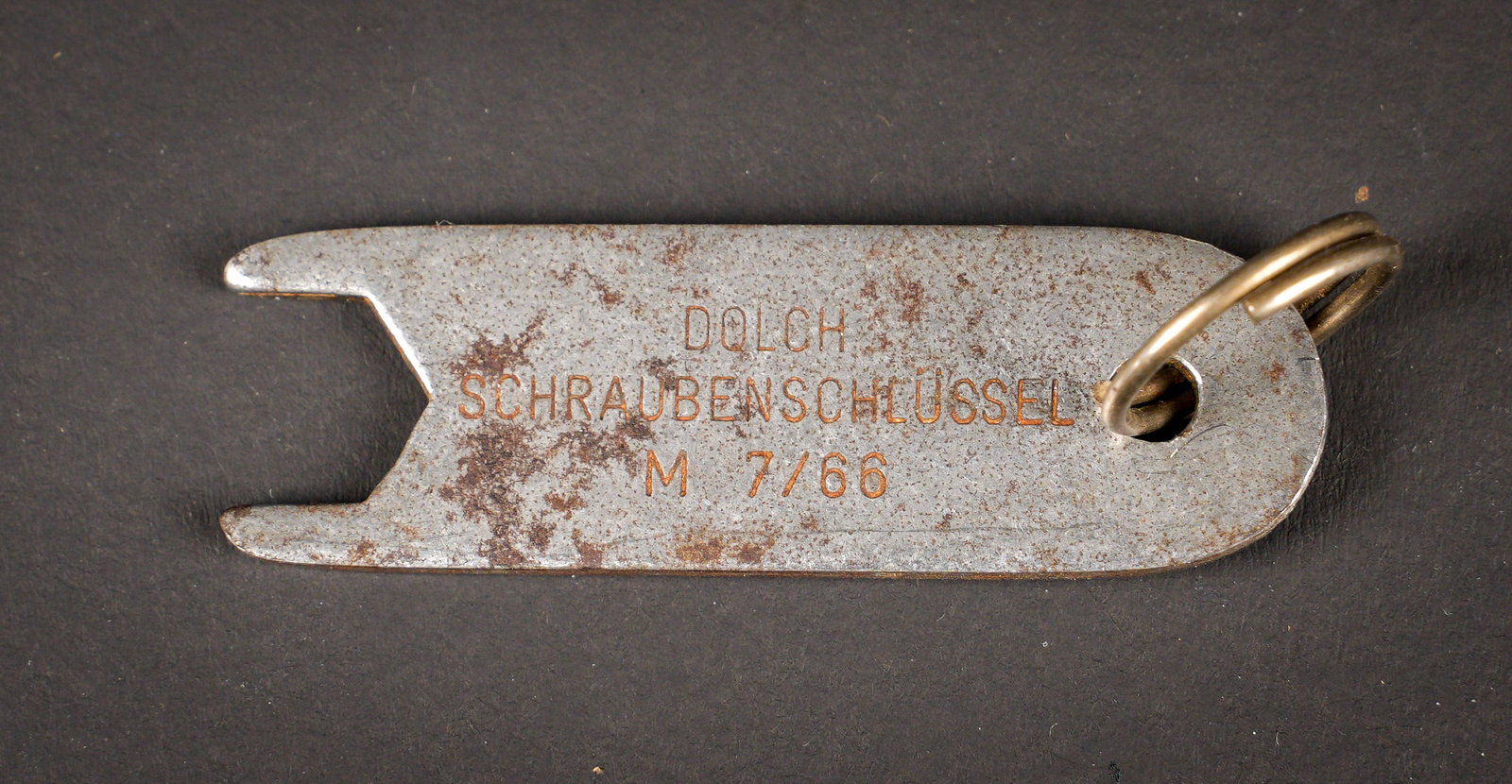 Cle de demontage de dague. Dagger disassembly key.: Cle de demontage pour dague SA/SS/NSKK. En metal, marquee Dolch Schraubenschlussel M7/66. Le code RZM correspond au fabricant Carl Eickhorn, Solingen. A noter une certaine usure et oxydation de la