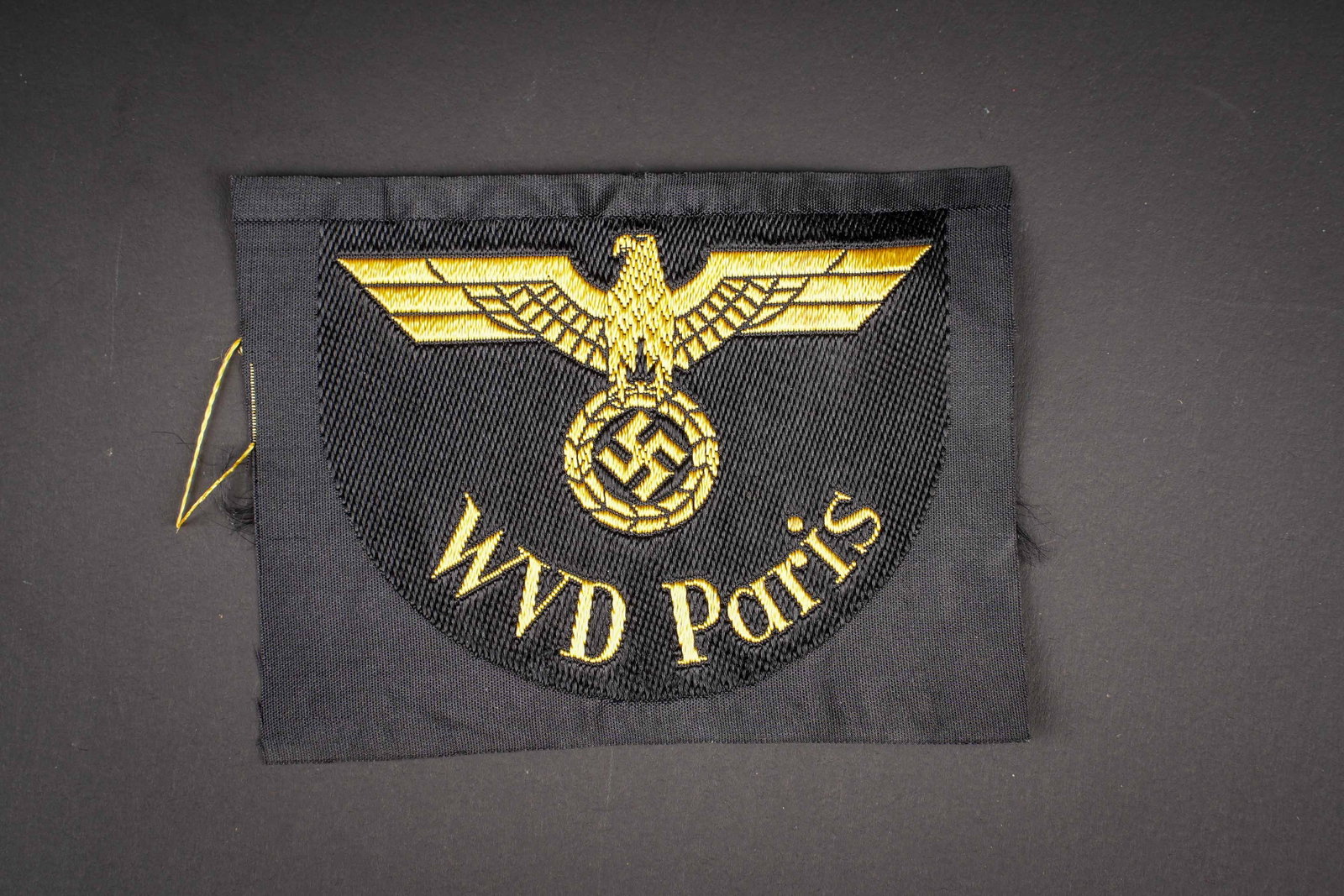 Insigne WVD Paris. VVD Paris insignia.: Insignes WVD Paris. Modele Bevo, jamais monte. A noter une legere usure et patine de la piece. Traces de scotch au dos. Etat I-. VVD Paris insignia. BeVo-woven example, never mounted. Showing slight