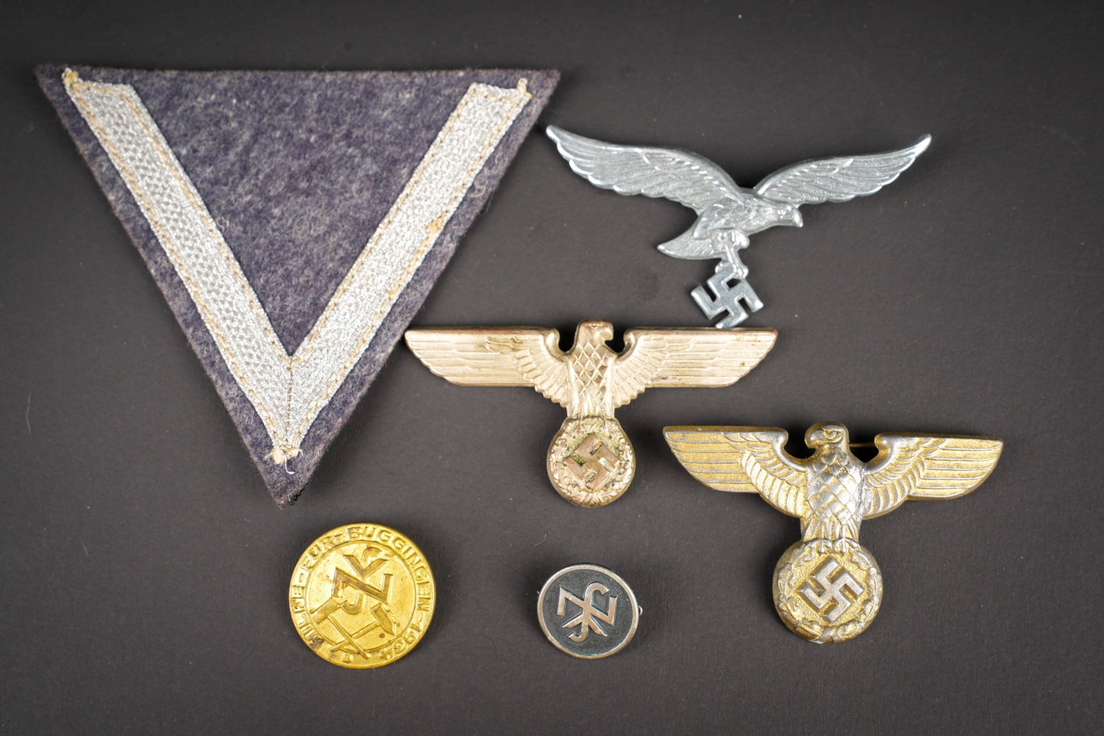 Insignes allemand. German Insignia.: Insignes allemand. Comprenant un aigle de coiffure SA, les ailes sont ressoudees, les attaches sont presentes. Un insigne NSV, attache complete. Un aigle de coiffure allemand, couleur argent, les