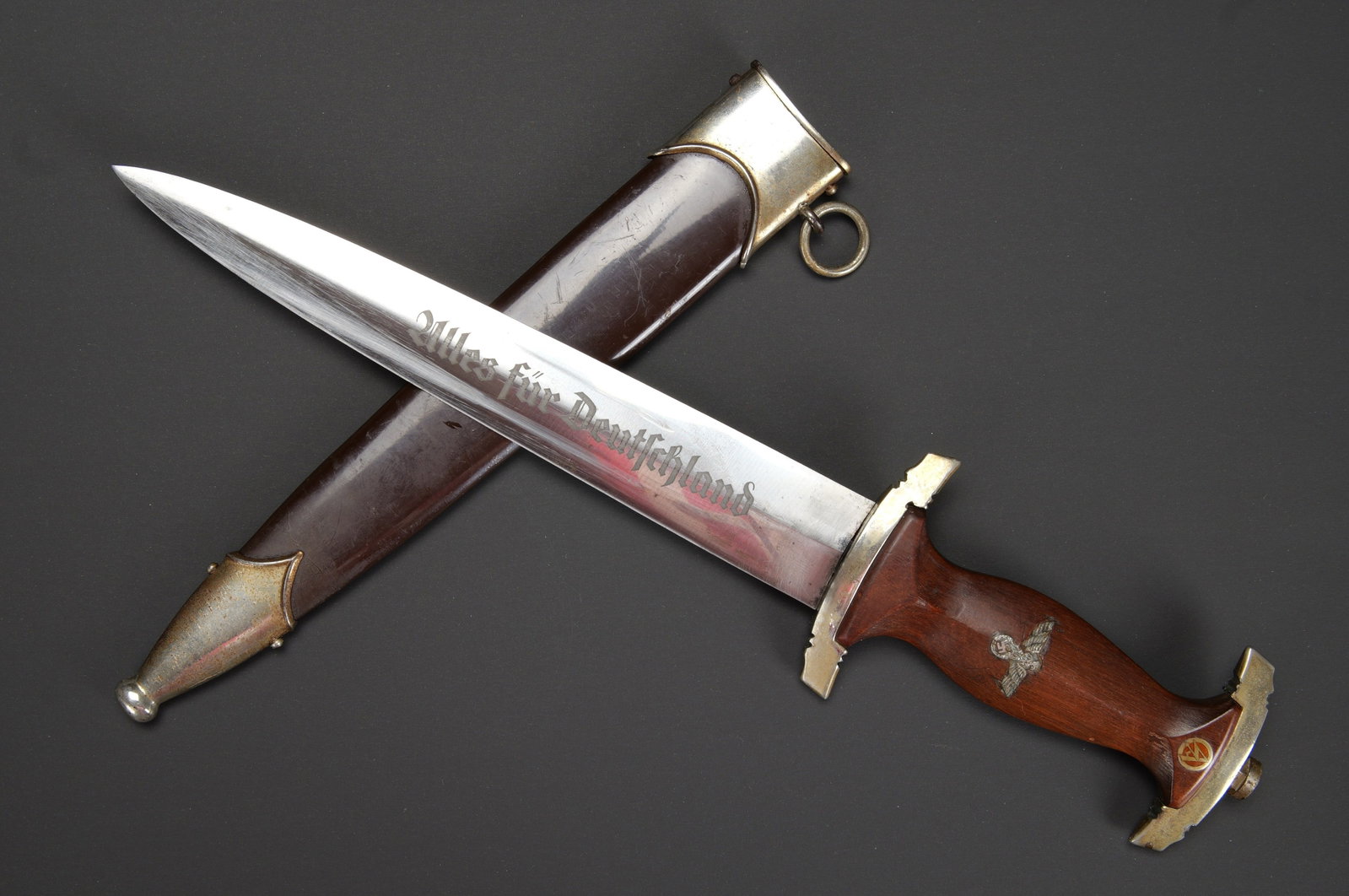 Dague SA. German SA dagger.: Dague SA. Garniture en metal nickele presentant des marques d oxydation. Poignee en bois marron. Insigne SA et aigle allemand montes d origine. Belle lame presentant quelques traces d usures. Devise