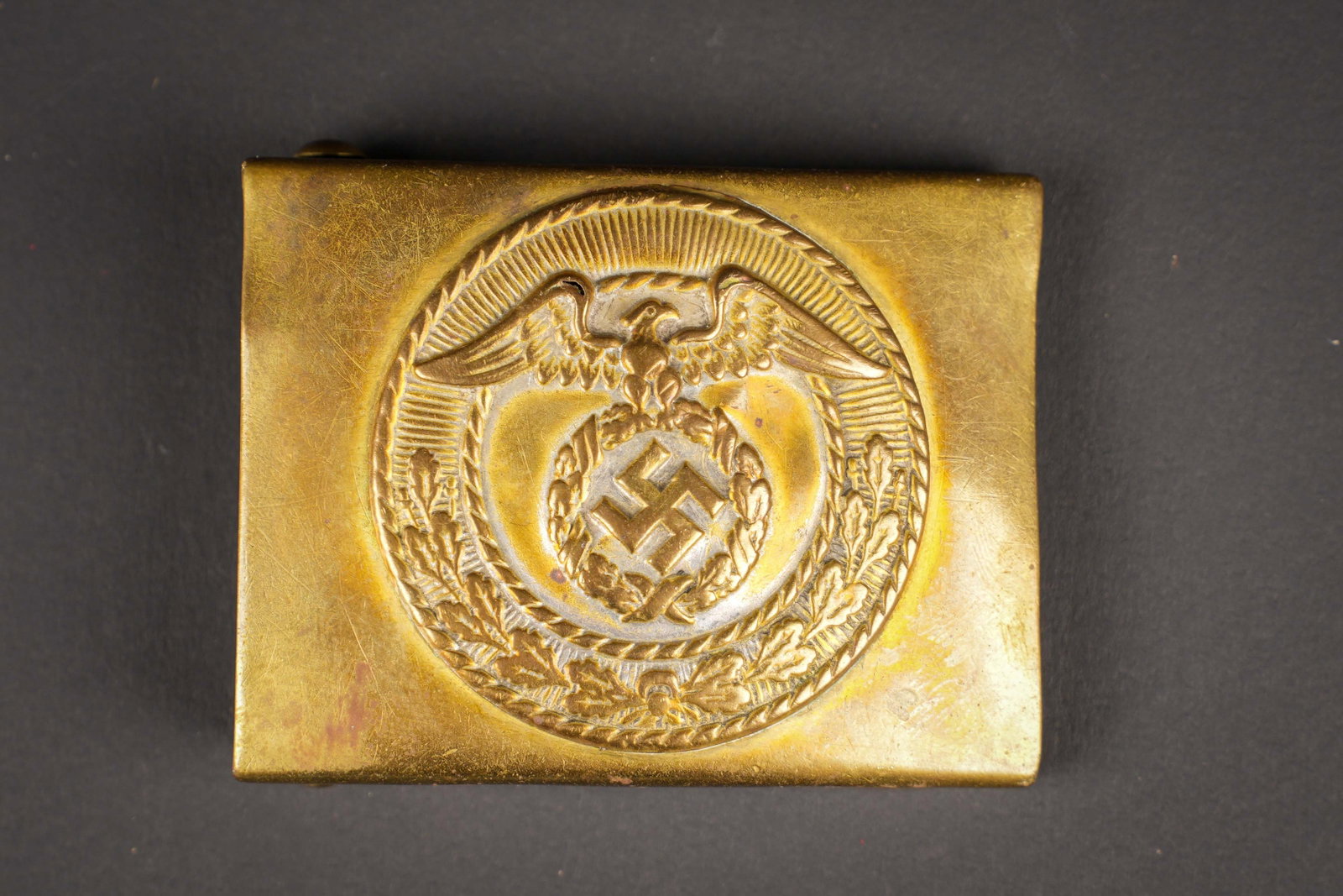 Boucle de ceinturon SA. German SA Belt Buckle.: Boucle de ceinturon SA. En laiton. Fabrication en deux parties. Ardillon complet. Quelques bosses visibles. Sans marquages visibles. A noter une certaine usure et patine de la piece. Etat II+. SA