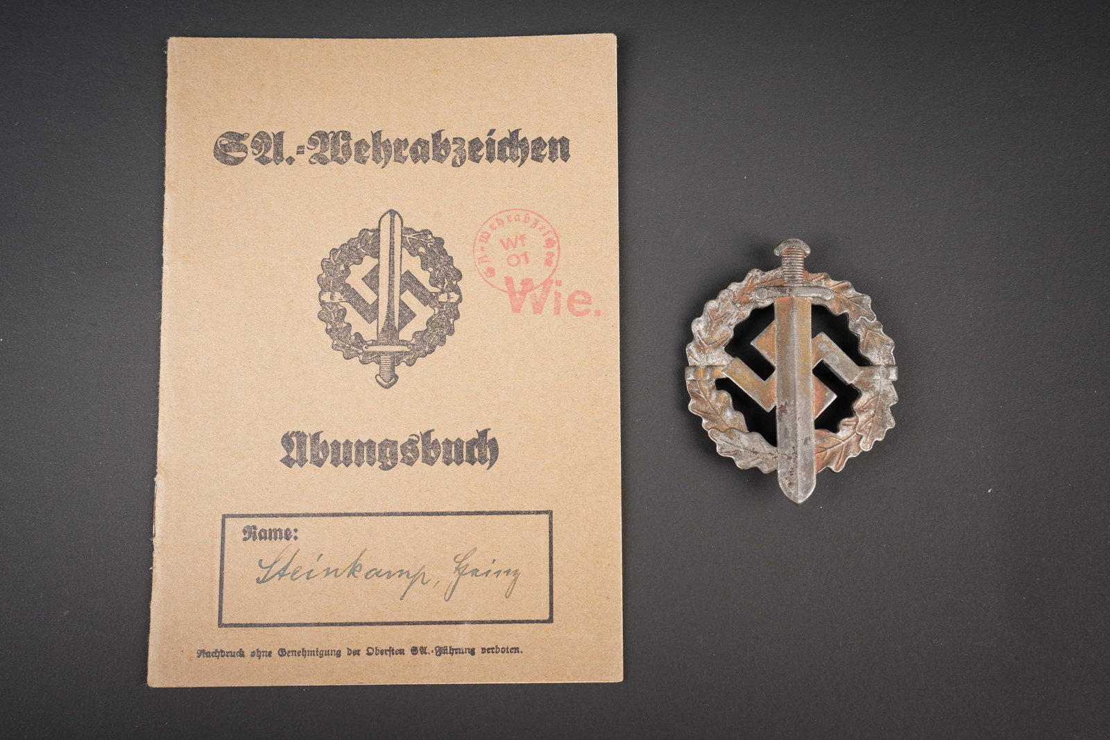 Brevet des sports SA. German SA Sport insignia.: Brevet des sports SA. Insigne en metal, couleur bronze. Attache complete. Fabrication W REDO SAAR Lautern. Livret papier, couverture marquee SA Wehrabzeichen, bien rempli, les indication nominatives