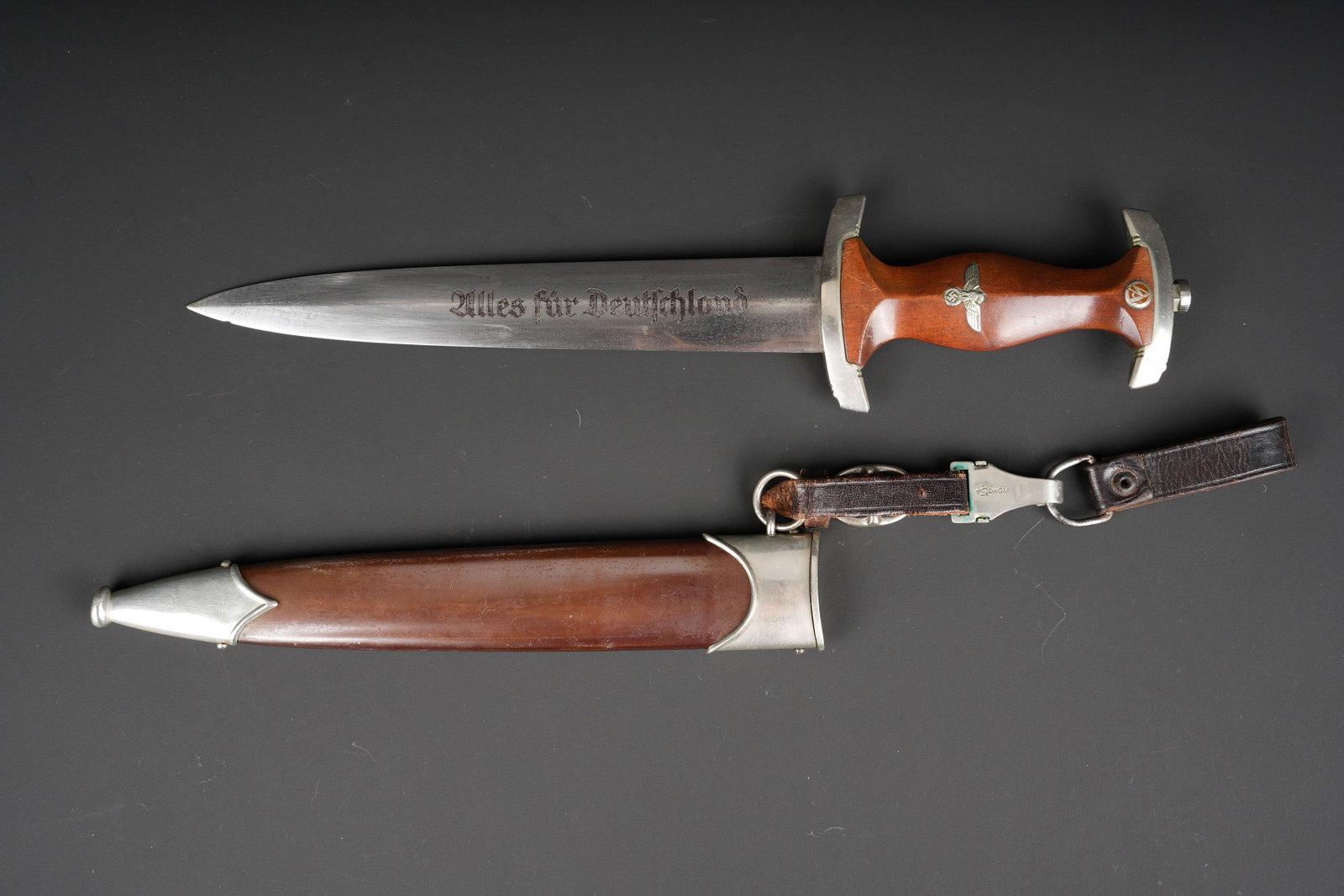 Dague de service SA. German SA Dagger: Dague de service de la SA. Garnitures metalliques. Garde portant les initiales WM. Poignee en bois. Insigne SA et aigle national allemand visiblement montes d origine. Belle lame complete, quelques