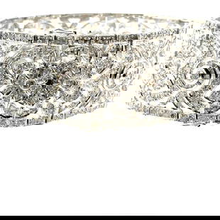 18k White Gold & Diamond Bracelet: Ladies 18k white gold & diamond tennis bracelet measuring 7 1/4" long by 30mm wide. Flexible style with box clasp and 2 safety figureeight clasps. Bezel set through the middle are a total of 11 full c
