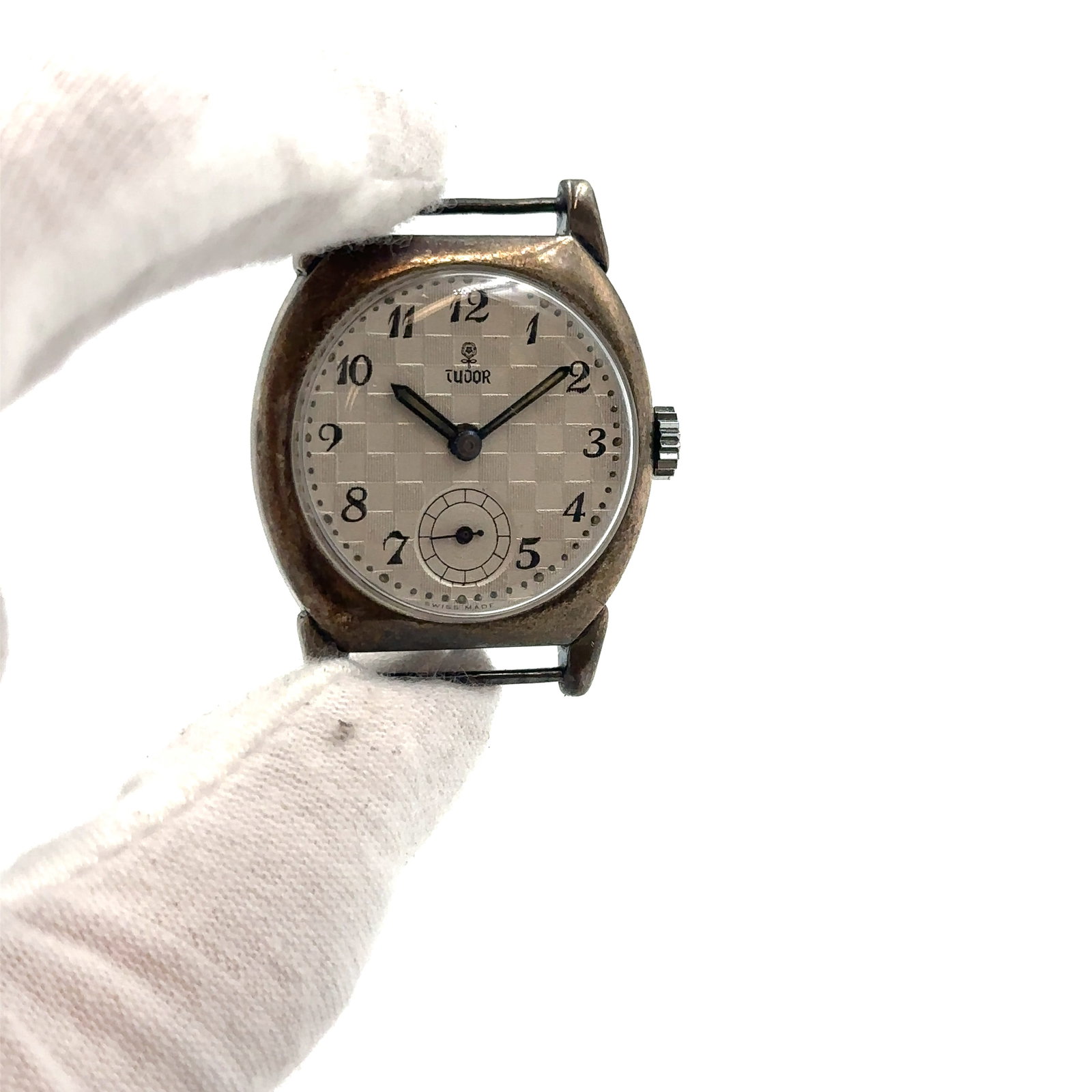 Tudor By Rolex: Vintage Tudor Ladies Watch features a stainless steel bezel and a checkered white dial with Arabic numerals, exuding luxury and classic style. This Swiss-made timepiece boasts a self-winding mechanica