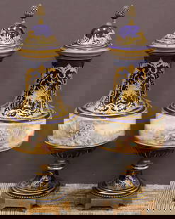 Pair of Antique French Sevres porcelain covered urns: A stunning pair of hand painted signed Sevres porcelain urns, the central portions feature courting scenes with lovers at the water's edge fishing all within a wooded landscape. The unique cascading f