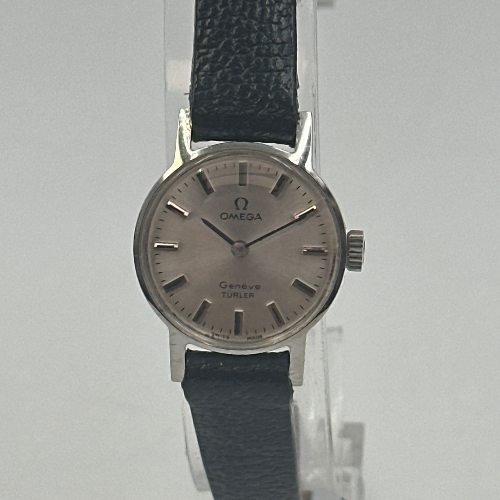 Omega Geneve Turler With Original Box: Omega geneve turler. Silver dial with silver coloured hands and numeral markers. Case size 17 mm. Manual wind. New black leather strap. Comes with original box.