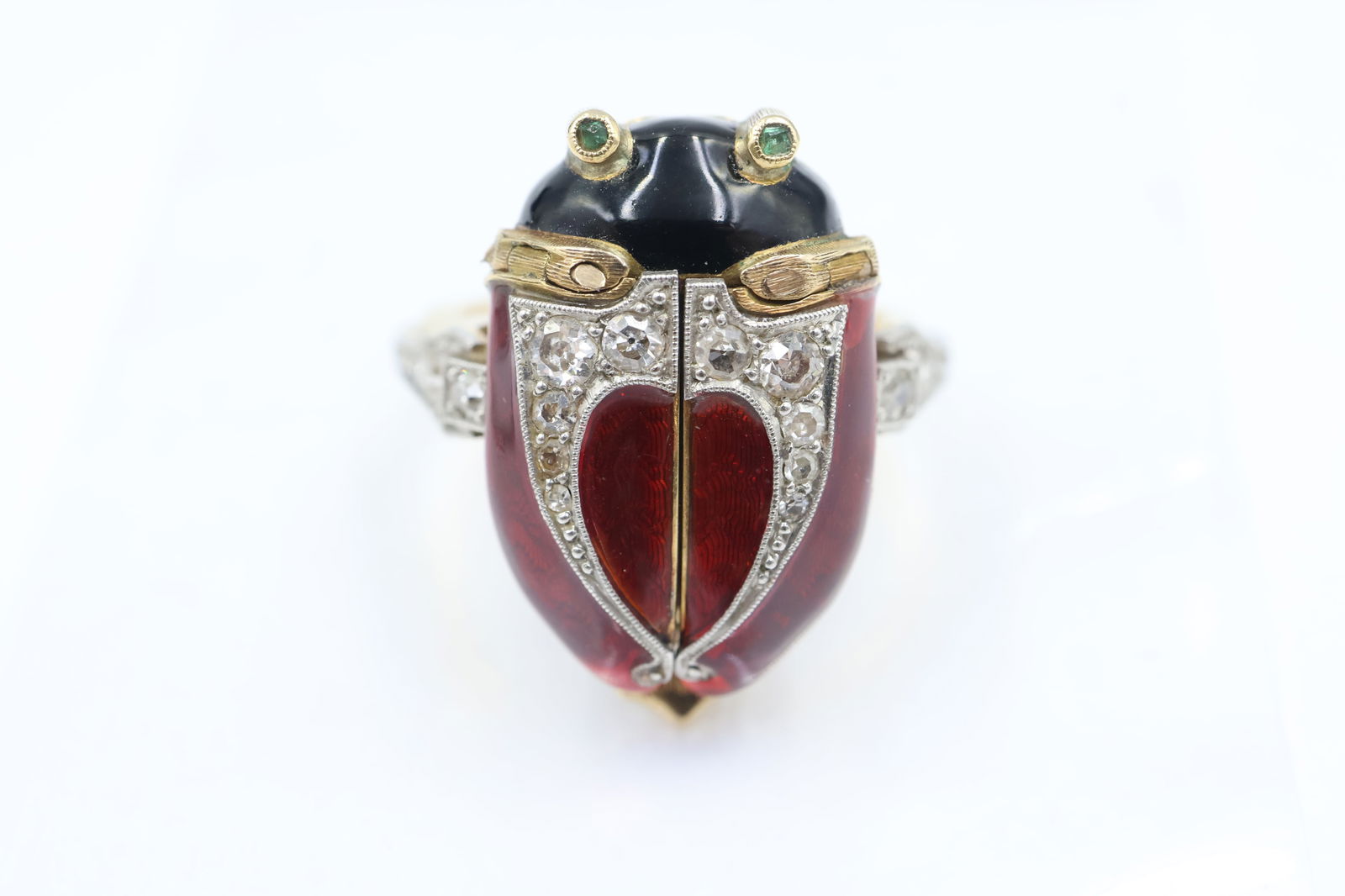 Antique 18k Gold Ladybug Ring Watch c.1900s: Antique ladybug ring watch, circa 1900s. 18k yellow and white gold. Hinged enamel wings (black and red) reveal a Swiss 15–17-jewel movement. Two emerald eyes. Shank set with 14 old European cut