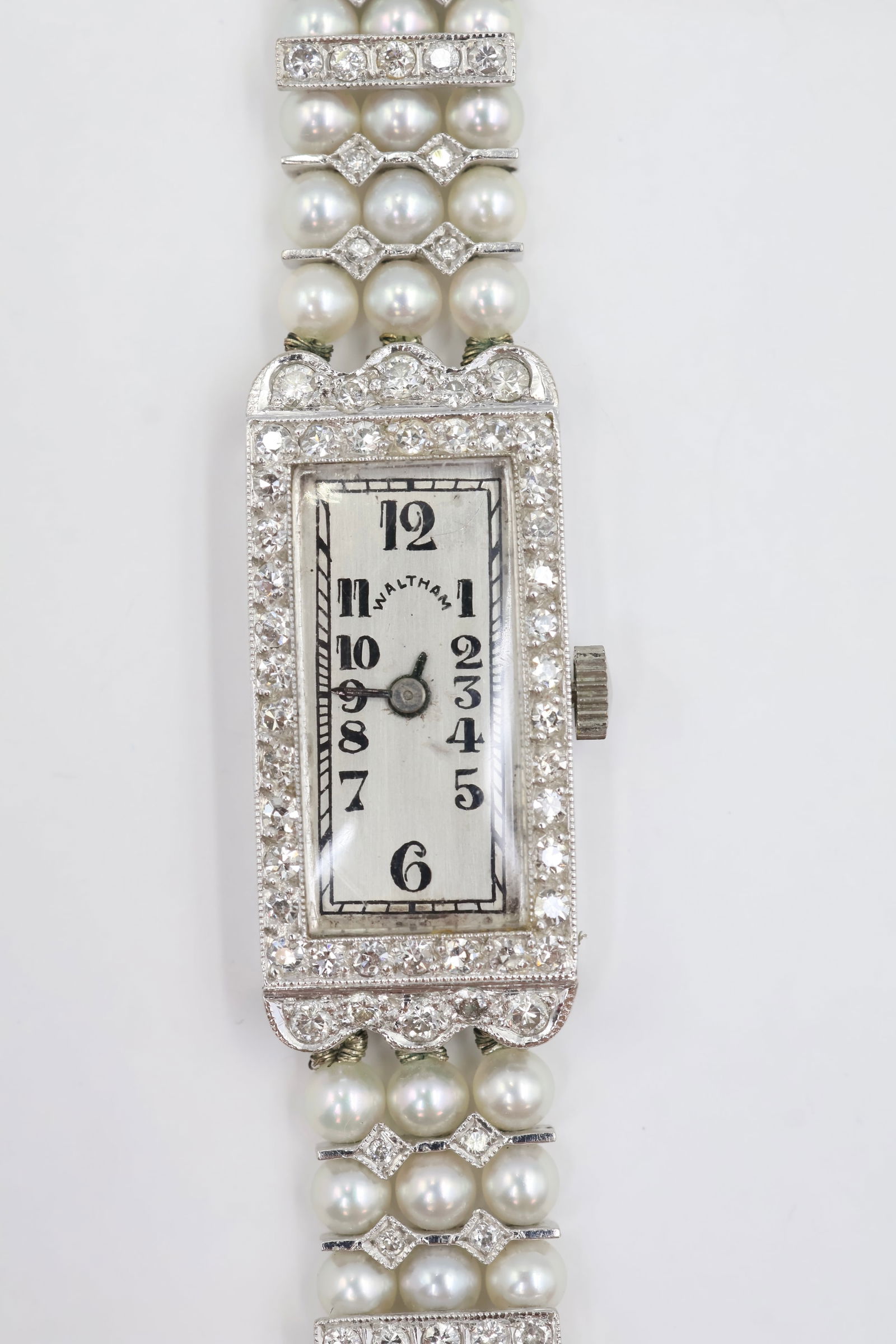 Vintage Waltham 18k Gold Diamond Pearl Watch: Vintage Waltham ladies' watch in 18k white gold on a diamond and cultured pearl bracelet. Engraved on caseback: ABJ. Total weight: 25g.