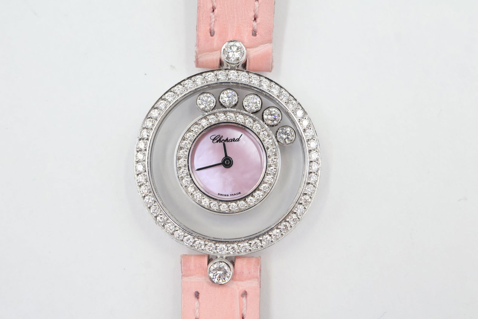 Chopard Happy Diamonds Watch — Box & Cert.: Chopard Happy Diamonds ladies' quartz watch. 26mm white gold case. Silver mother-of-pearl dial with diamond accents. Pink leather strap (6-inch wrist). Presented with winding key, original box, and