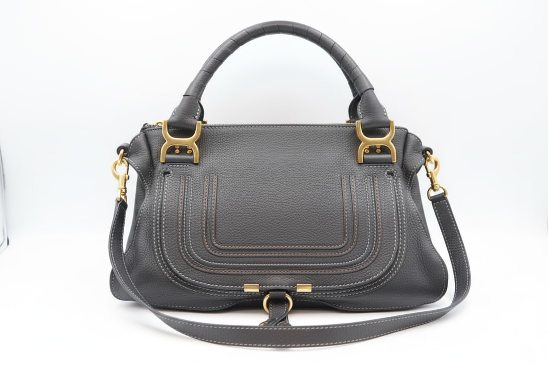 Chloé Marcie Black Leather Shoulder Bag: Chloé Marcie shoulder bag in black leather with gold toned hardwrae like-new condition. Stitched saddle flap, lobster claw closure, Chloé C ring detail. Dimensions: 12" W × 9" H × 3.5" D. Date