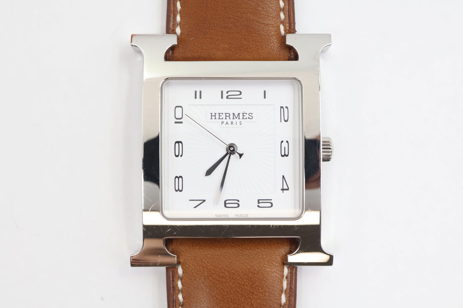 Hermès Heure H Quartz — Ref HH1.810: Hermès Heure H quartz watch, reference HH1.810. 34mm H-shaped stainless steel case. White dial. Sapphire crystal. Brown leather strap (up to 7-inch wrist). 12-jewel movement. Like-new condition.
