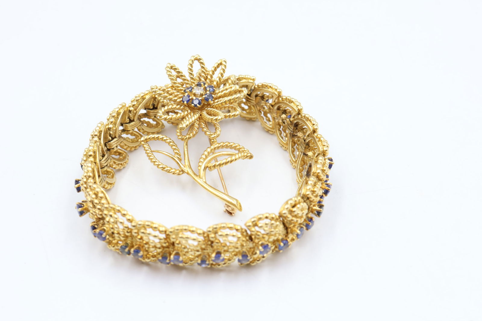 Vintage Tiffany 18k Gold Sapphire Brooch Set: Vintage Tiffany & Co. set comprising a sapphire brooch and matching bracelet, both in 18k gold. Brooch set with 6 sapphires and 1 diamond. Combined weight: 74.1g. Stamped Tiffany & Co., 750.