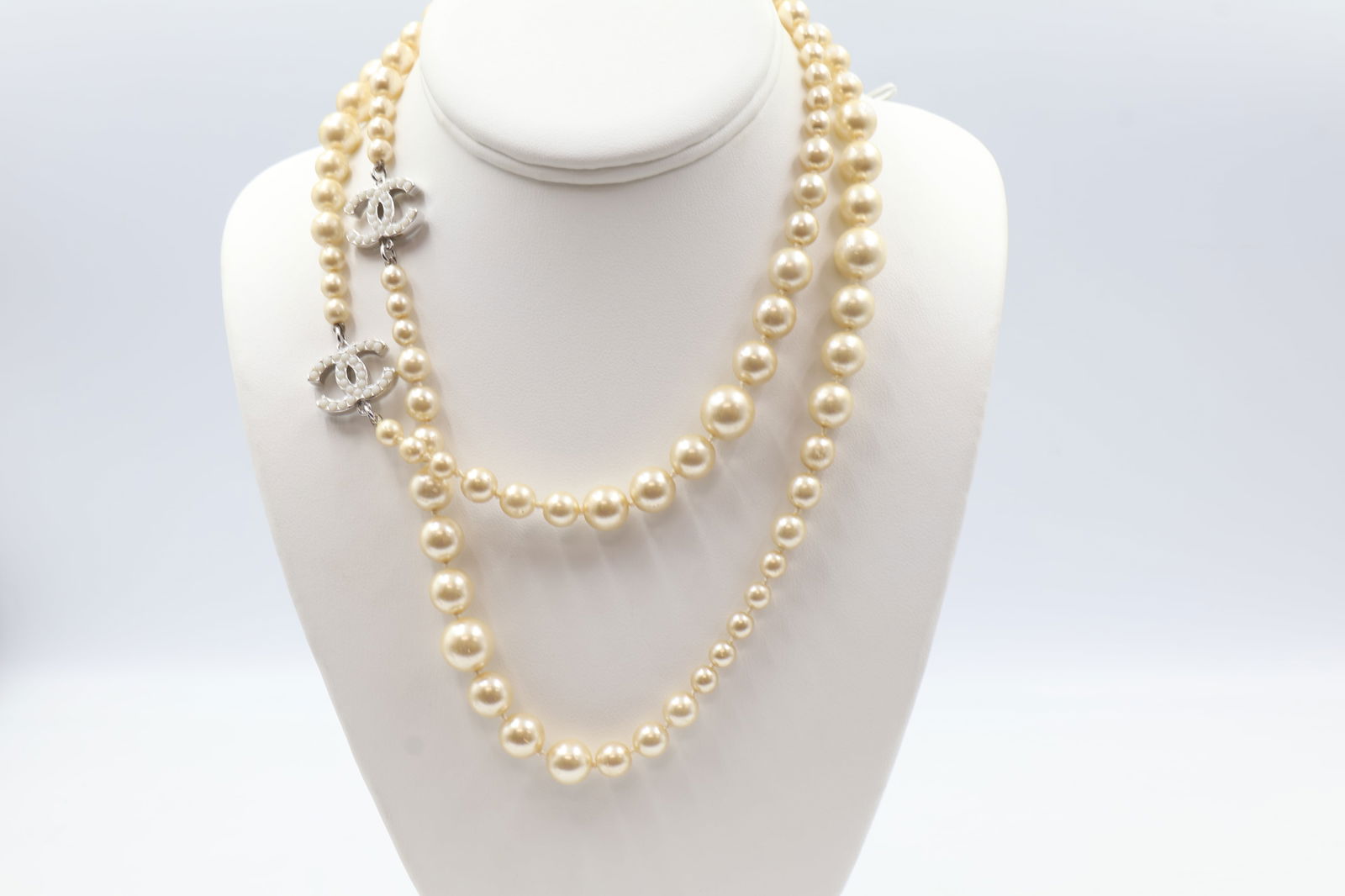 Chanel Faux Pearl CC Charm Necklace — 34 in.: Chanel faux pearl necklace with silver-tone hardware and two CC charms with faux pearl accents. Lobster clasp. Length: 34 inches. Some wear to pearl tone consistent with age.