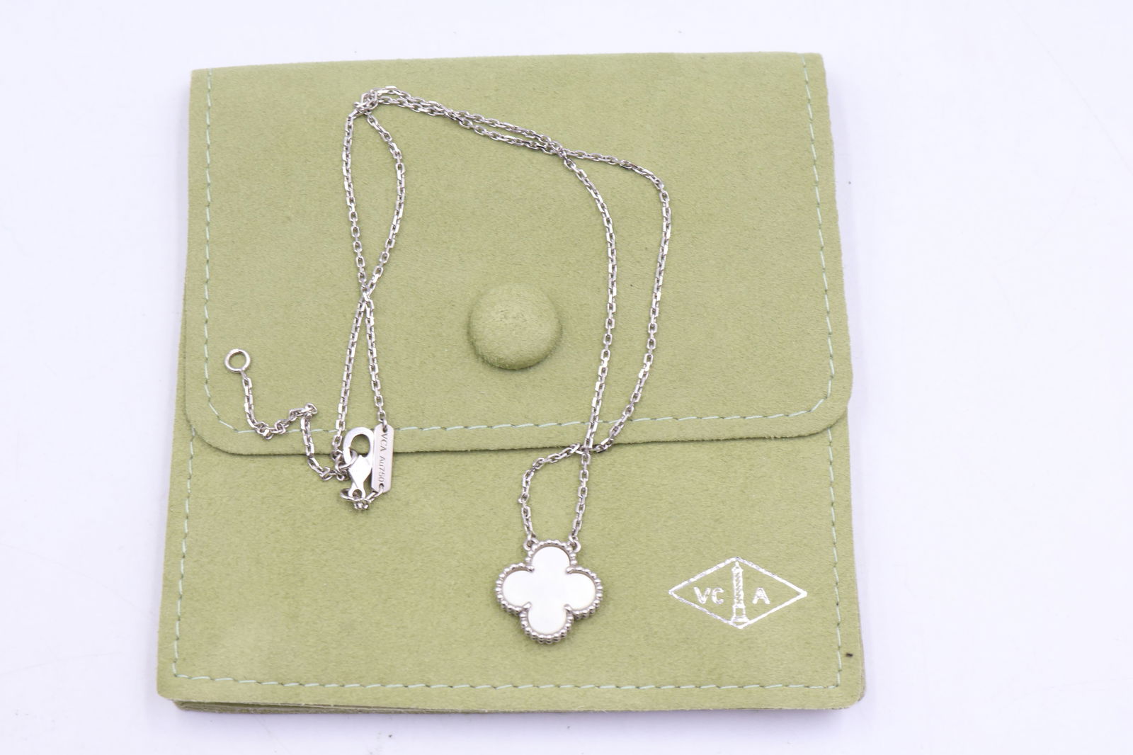 Van Cleef Alhambra MOP Pendant — 18k WG Box: Van Cleef & Arpels Single Alhambra pendant in 18k white gold set with mother of pearl, on an 18k white gold chain. Presented with original box, pouch, and certificate of authenticity. Stamped VCA,