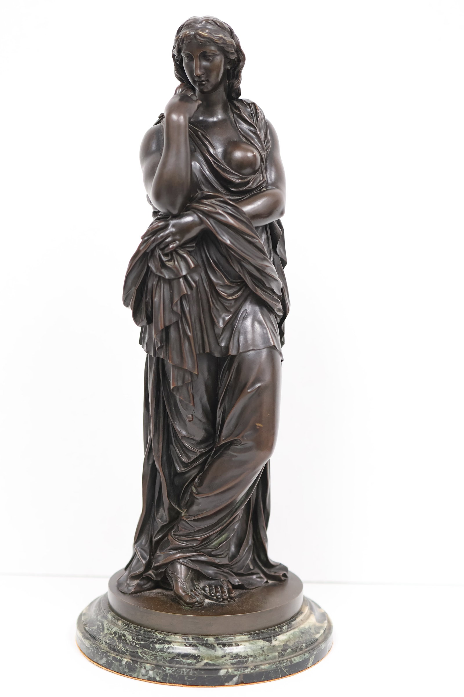 Unknown, European School, early 20thCentury: A cast bronze figural study showing a classically clad standing female with elaborate draped gown. The whole rests on a stepped marble circular plinth. Signed indistinctly to the reverse. Dimensions: