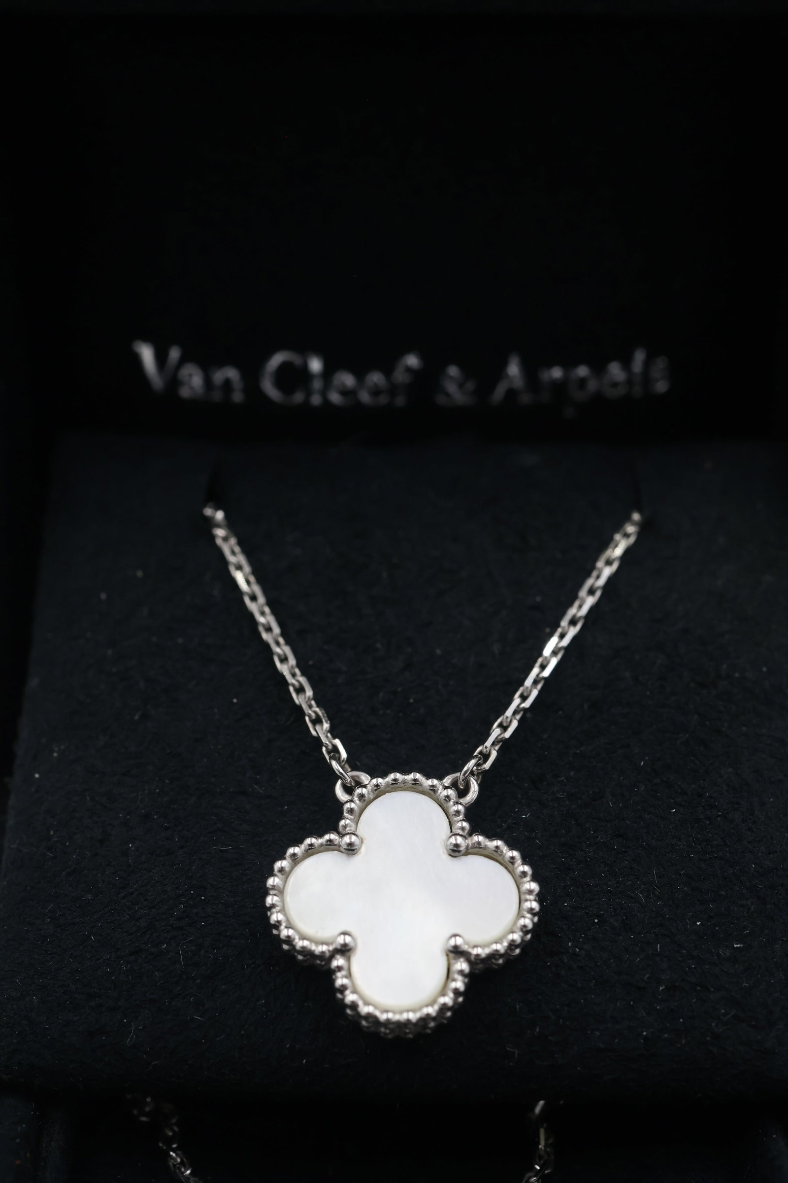 Van Cleef & Arpels 18k white Gold & Mother of Pearl Alhambra Pendent: Iconic Van Cleef & Arpels Alhambra pendant crafted in 18K white gold and set with luminous mother-of-pearl. An elegant and instantly recognizable design from one of the Maison’s most celebrated coll