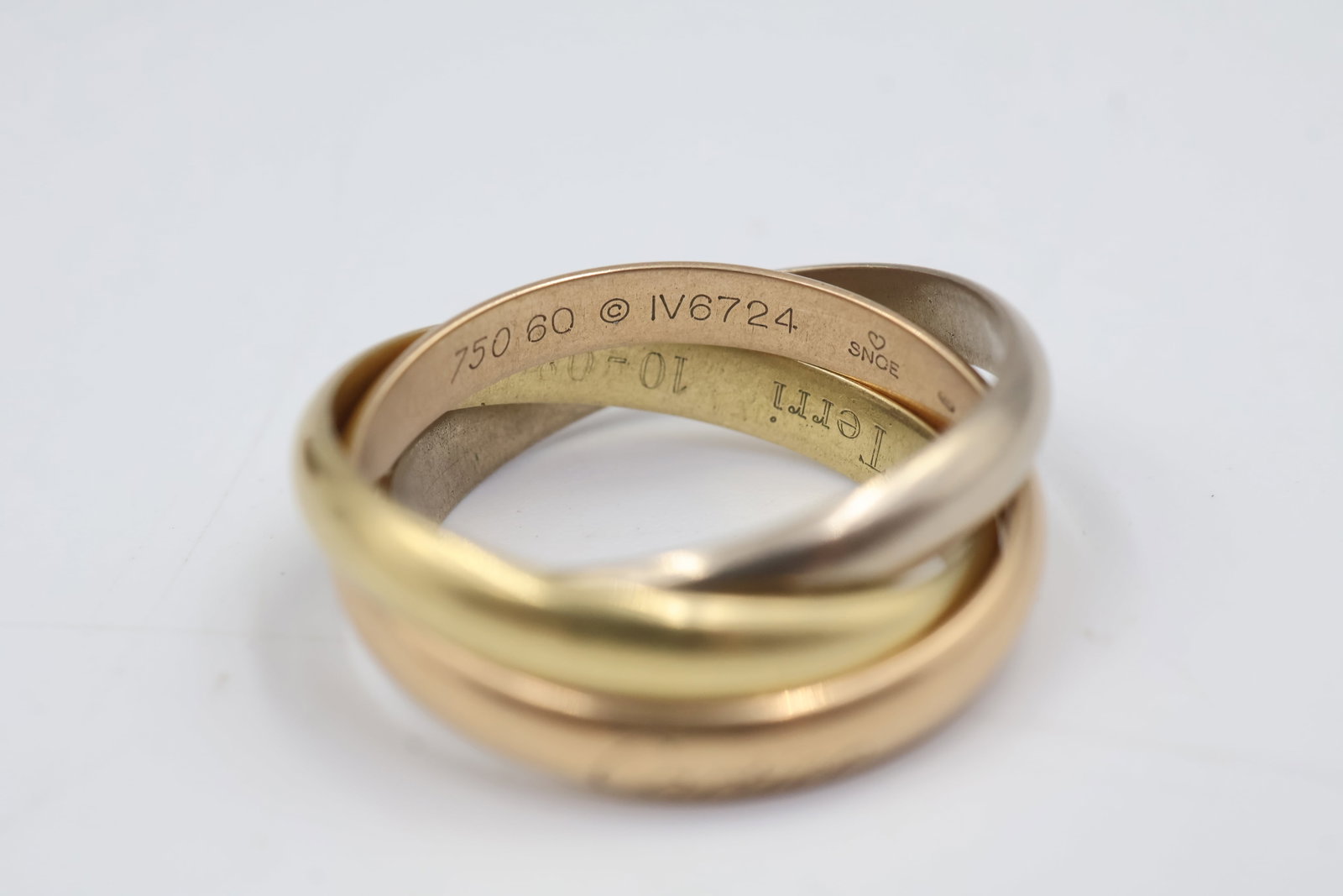 Cartier 18k Tri Gold Ring With Certificate Of Authenticity: Cartier Infinity ring crafted in 18K tri-colour gold. A timeless interlocking design combining yellow, white and rose gold, showcasing Cartier’s signature sophistication and craftsmanship. Size 7. W