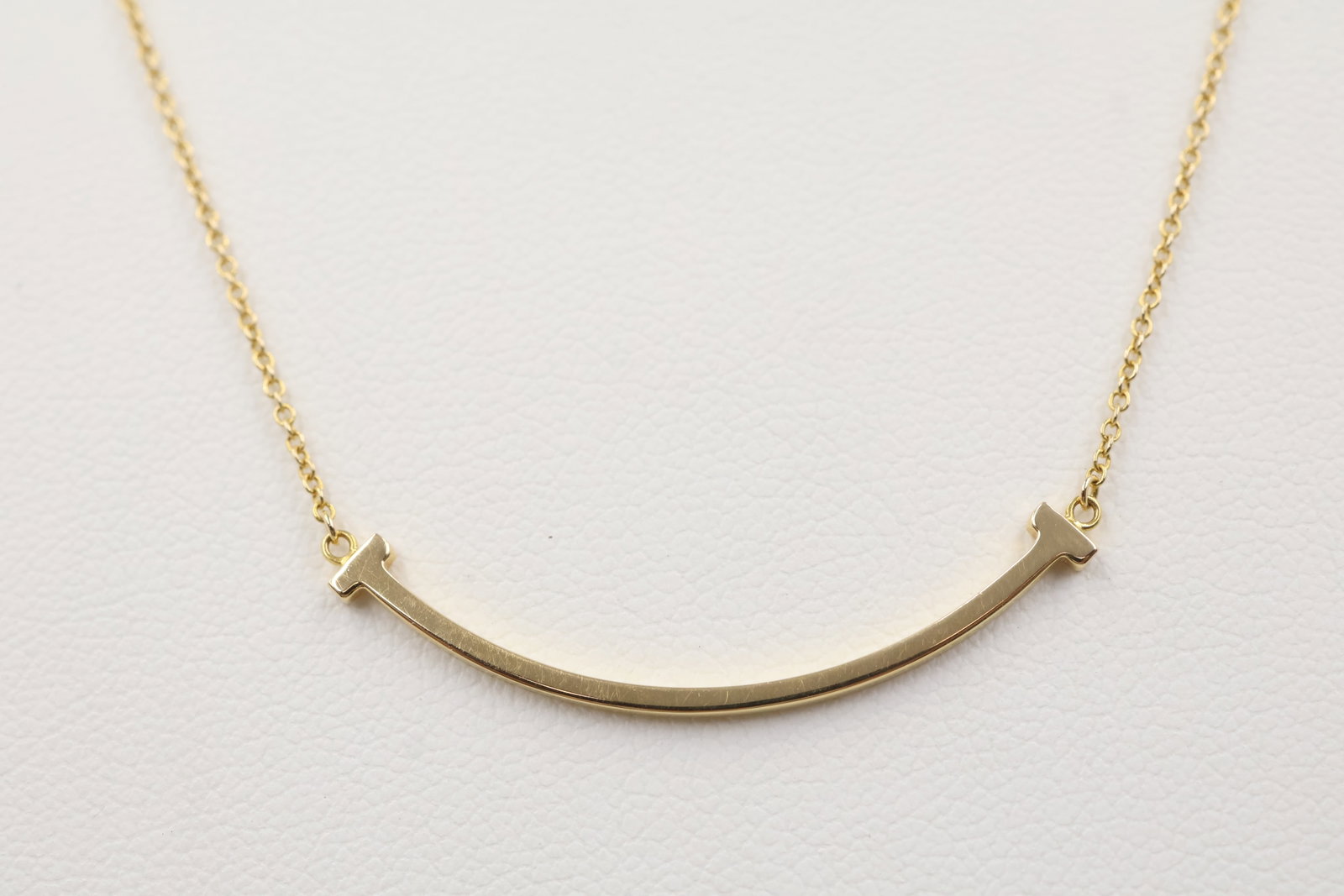 Tiffany & Co 18k Yellow Gold Smile Necklace: Tiffany & Co. necklace crafted in 18K yellow gold, featuring the iconic Smile design. Total weight: 2.8 grams. Accompanied by a Tiffany & Co. box.