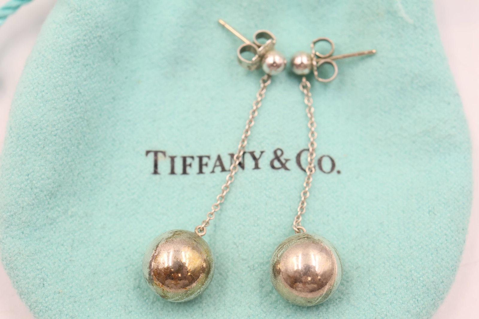 Tiffany & Co Sterling Silver Drop ball earrings: Tiffany & Co. drop earrings crafted in sterling silver, featuring classic polished ball drops. Total weight: 5 grams.