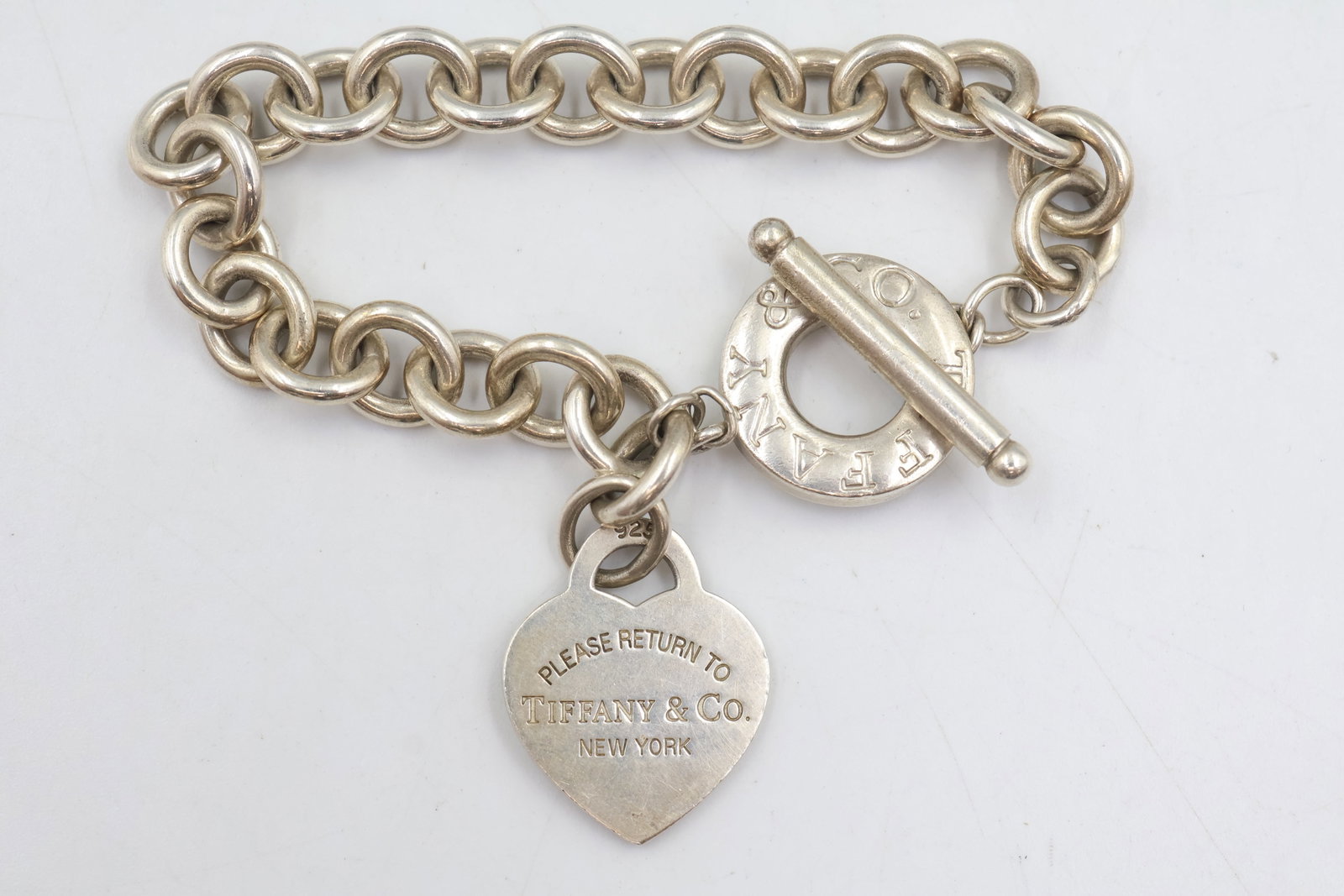 Tiffany & Co 925 Toggle Charm Bracelet: Tiffany & Co. bracelet crafted in 925 sterling silver, featuring a signature toggle clasp and charm design. Measures approximately 6¾ inches. Total weight: 41.4 grams.