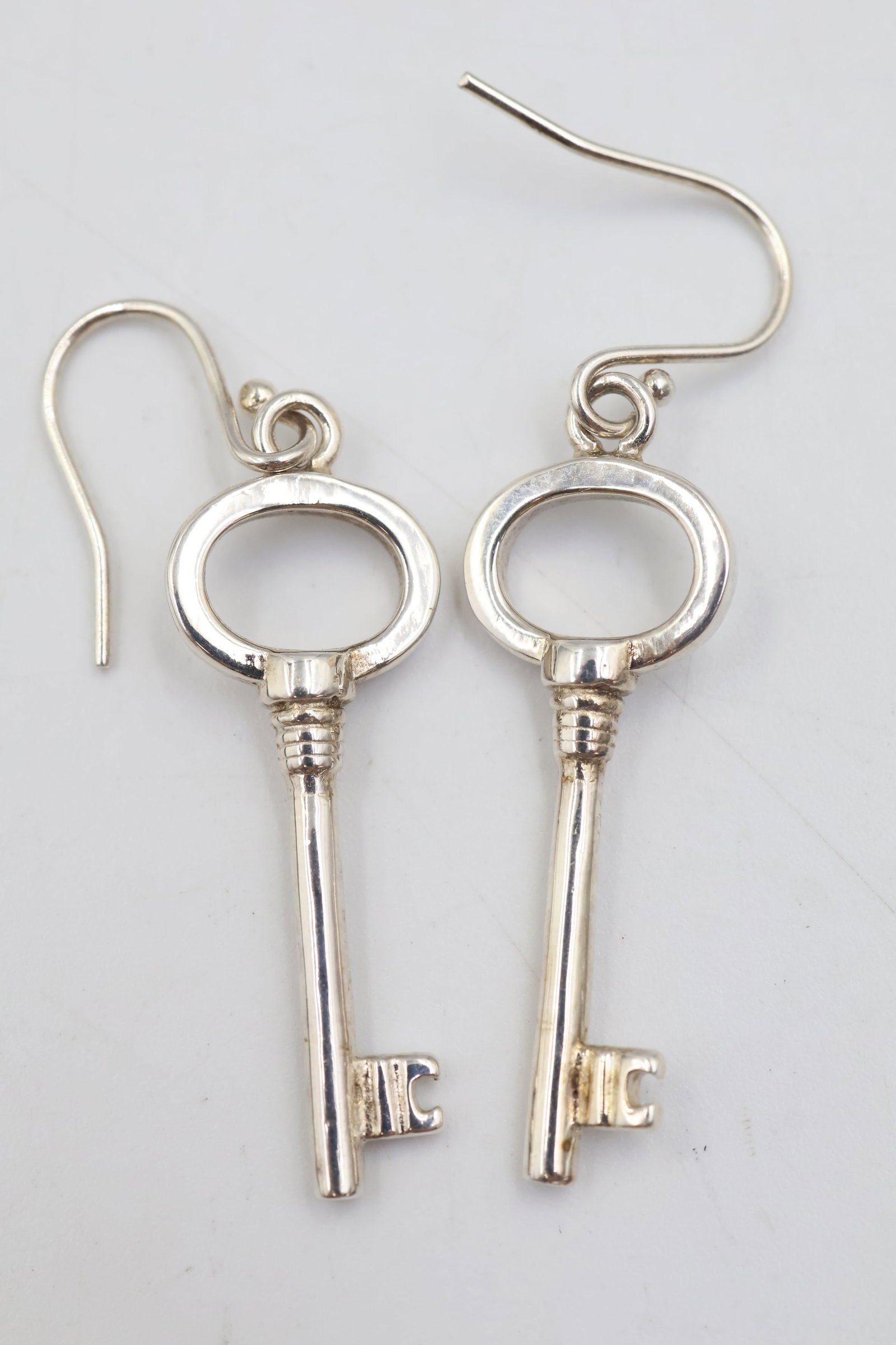 Tiffany & Co 925 Sterling Silver Key Earrings: Tiffany & Co. earrings crafted in 925 sterling silver, featuring the iconic key motif. Total weight: 4.5 grams. Accompanied by a Tiffany & Co. pouch.