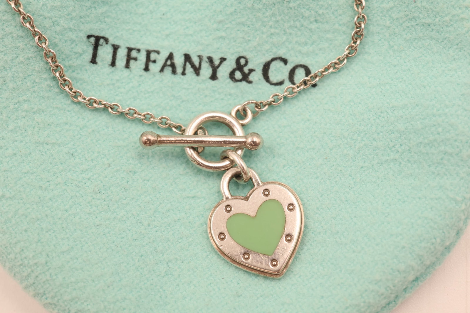 Tiffany & Co 925 Heart Padlock Toggle Bracelet: Tiffany & Co. bracelet featuring a heart-shaped padlock charm and toggle closure, crafted in sterling silver. Total weight: 3.1 grams. Accompanied by a Tiffany & Co. pouch.