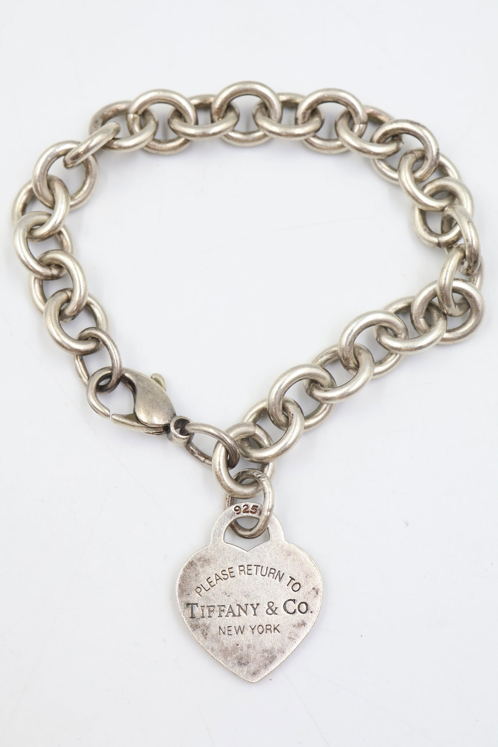 Tiffany & Co 925 Heart Charm Bracelet: Tiffany & Co. bracelet featuring a classic heart charm design. Total weight: 34.9 grams. Accompanied by a Tiffany & Co. pouch.