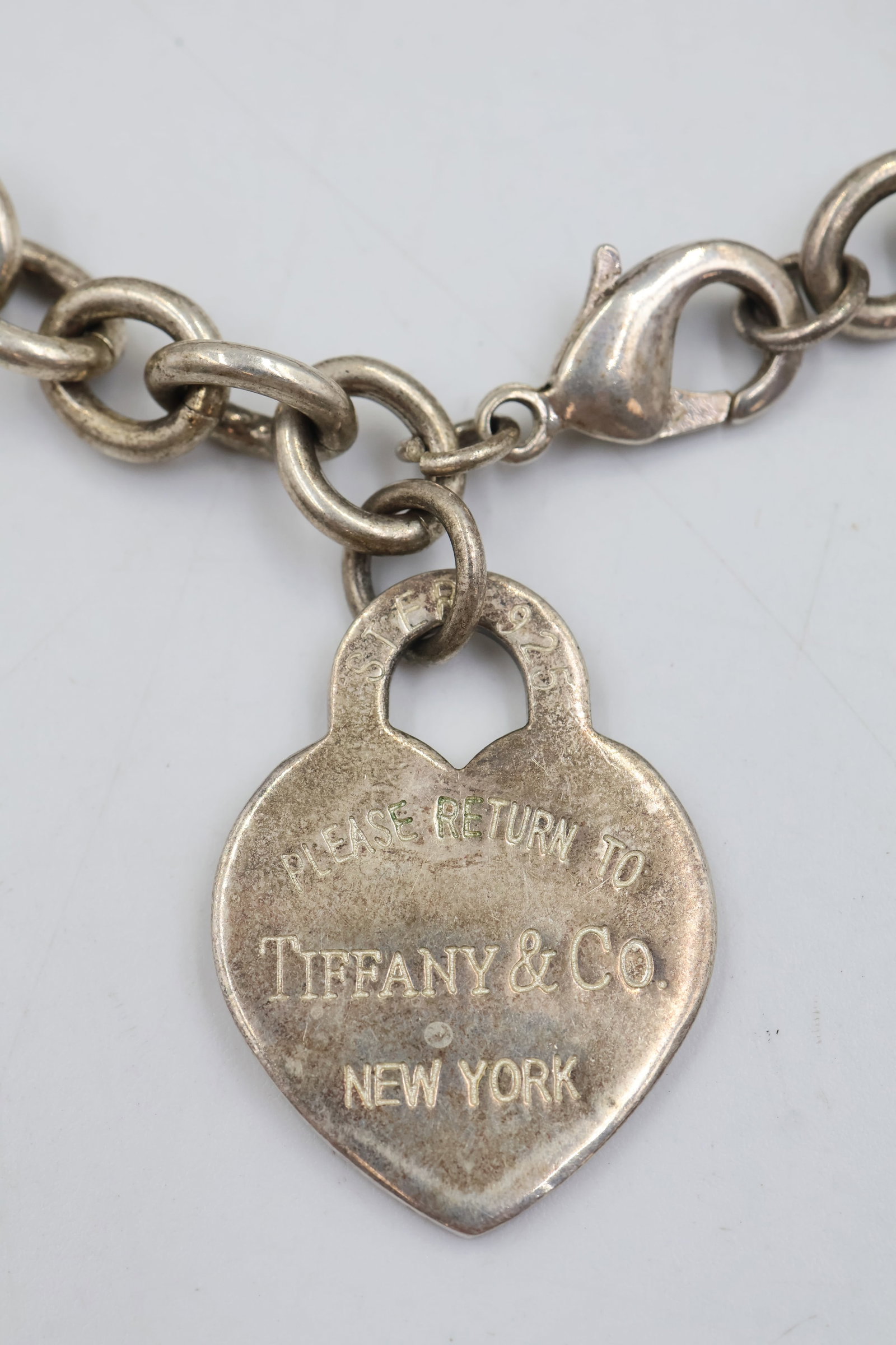 Tiffany & Co 925 Heart Charm Bracelet: Tiffany & Co. bracelet crafted in 925 sterling silver, featuring the iconic heart charm design. Measures approximately 6.5 inches. Total weight: 30.5 grams.