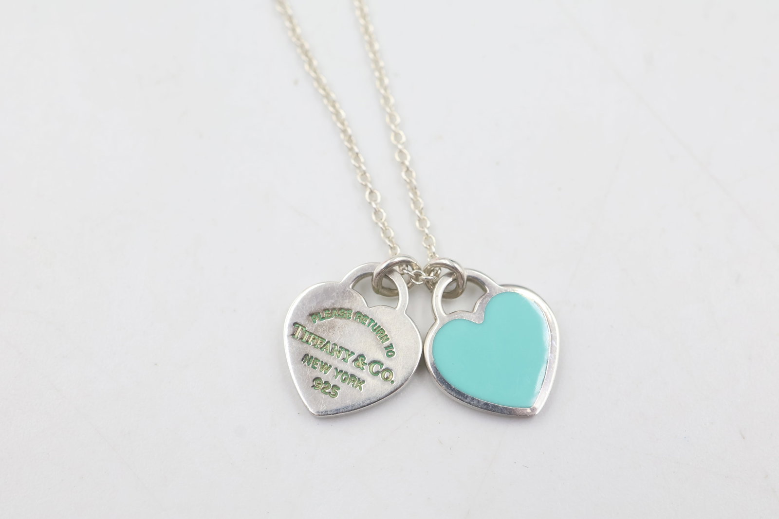 Tiffany & Co 925 Double Heart Pendant: Tiffany & Co. necklace featuring a classic double heart pendant crafted in sterling silver. Total weight: 2.8 grams. Accompanied by a Tiffany & Co. pouch.