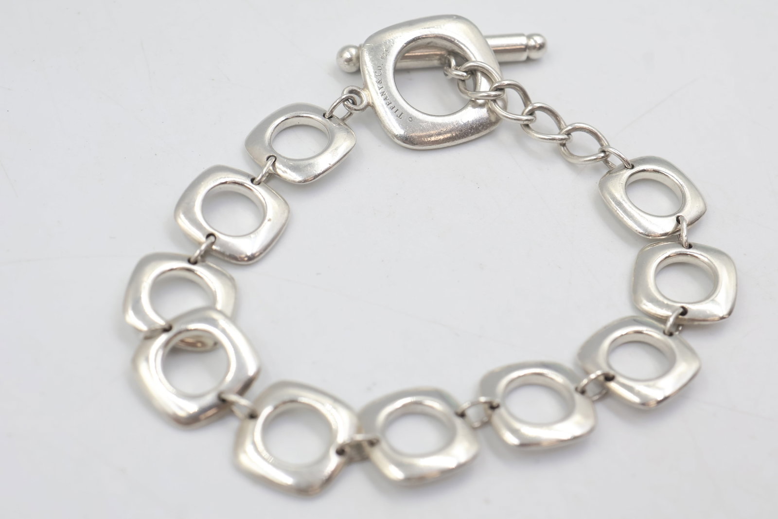 Tiffany & Co 925 Cushion Link Toggle Bracelet: Tiffany & Co. bracelet featuring substantial cushion-shaped links with a toggle closure, crafted in sterling silver. Total weight: 23.1 grams. Accompanied by a Tiffany & Co. pouch.