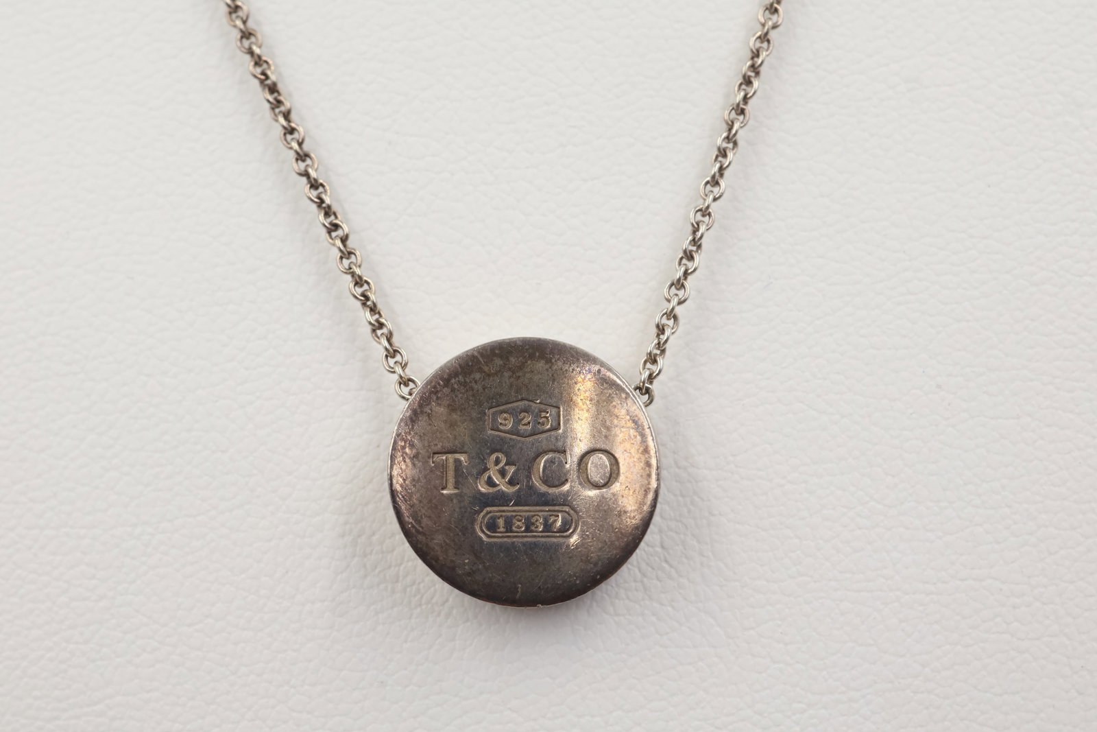 Tiffany & Co 1837 Sterling silver Concave Circle Necklace: Tiffany & Co. 1837 necklace featuring a distinctive concave circle pendant crafted in sterling silver. Total weight: 11.4 grams. Accompanied by a Tiffany & Co. pouch.