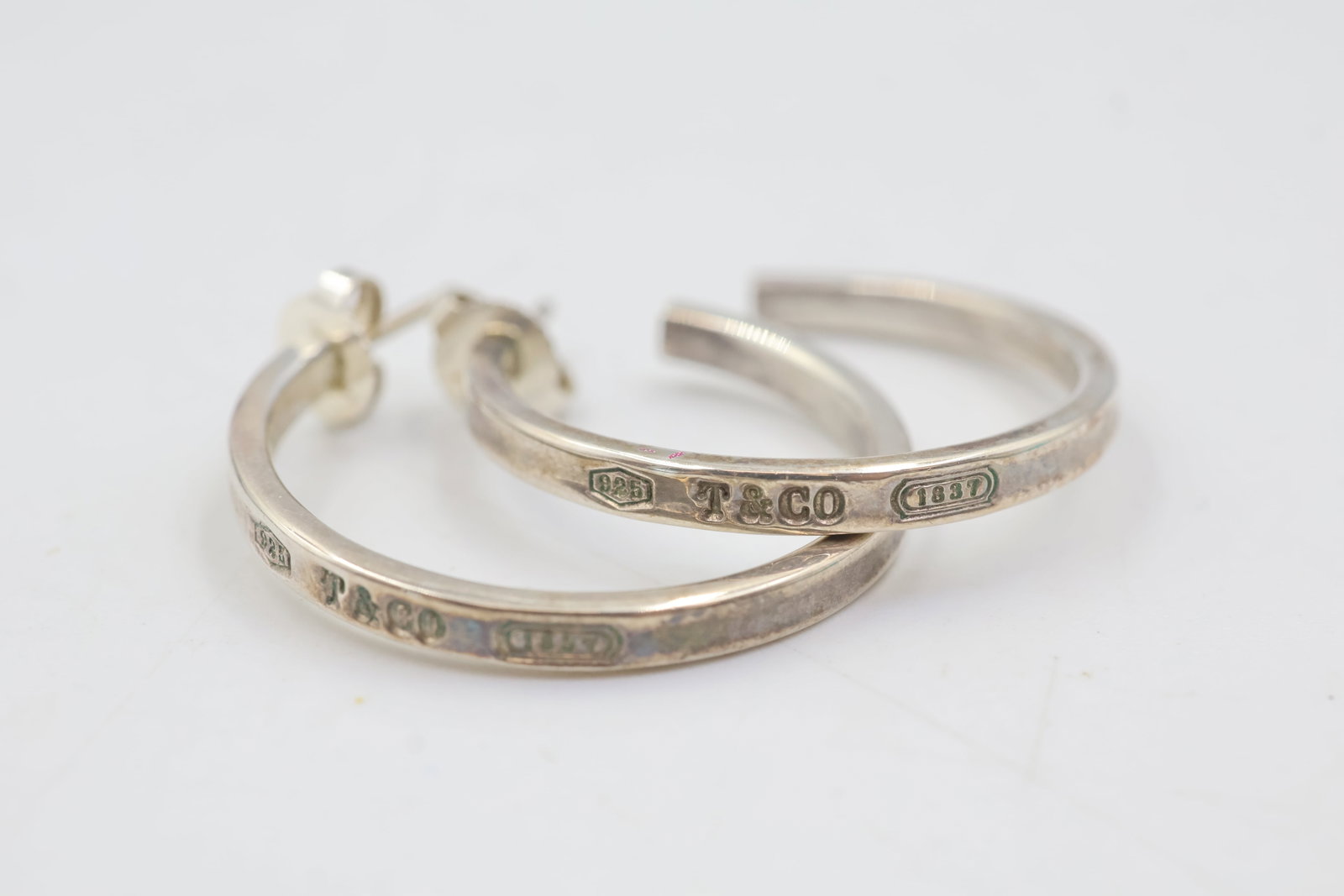 T & Co 1837 Sterling Silver Hoops: Tiffany & Co. 1837 hoop earrings crafted in sterling silver. Total weight: 6.2 grams. Accompanied by a Tiffany & Co. pouch.