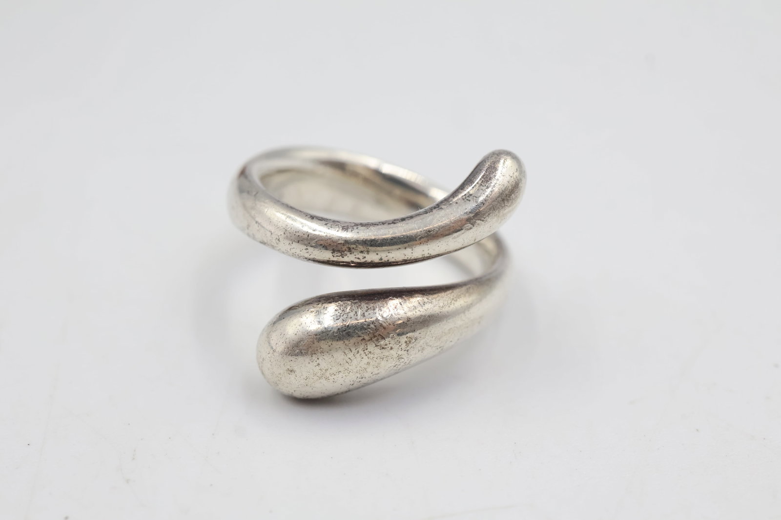 Elsa Peretti For Tiffany & Co Silver Teardrop Snake Wrap Ring: Elsa Peretti design for Tiffany & Co., crafted in sterling silver with an elegant teardrop snake wrap silhouette. Ring size: 6. Total weight: 9.8 grams.