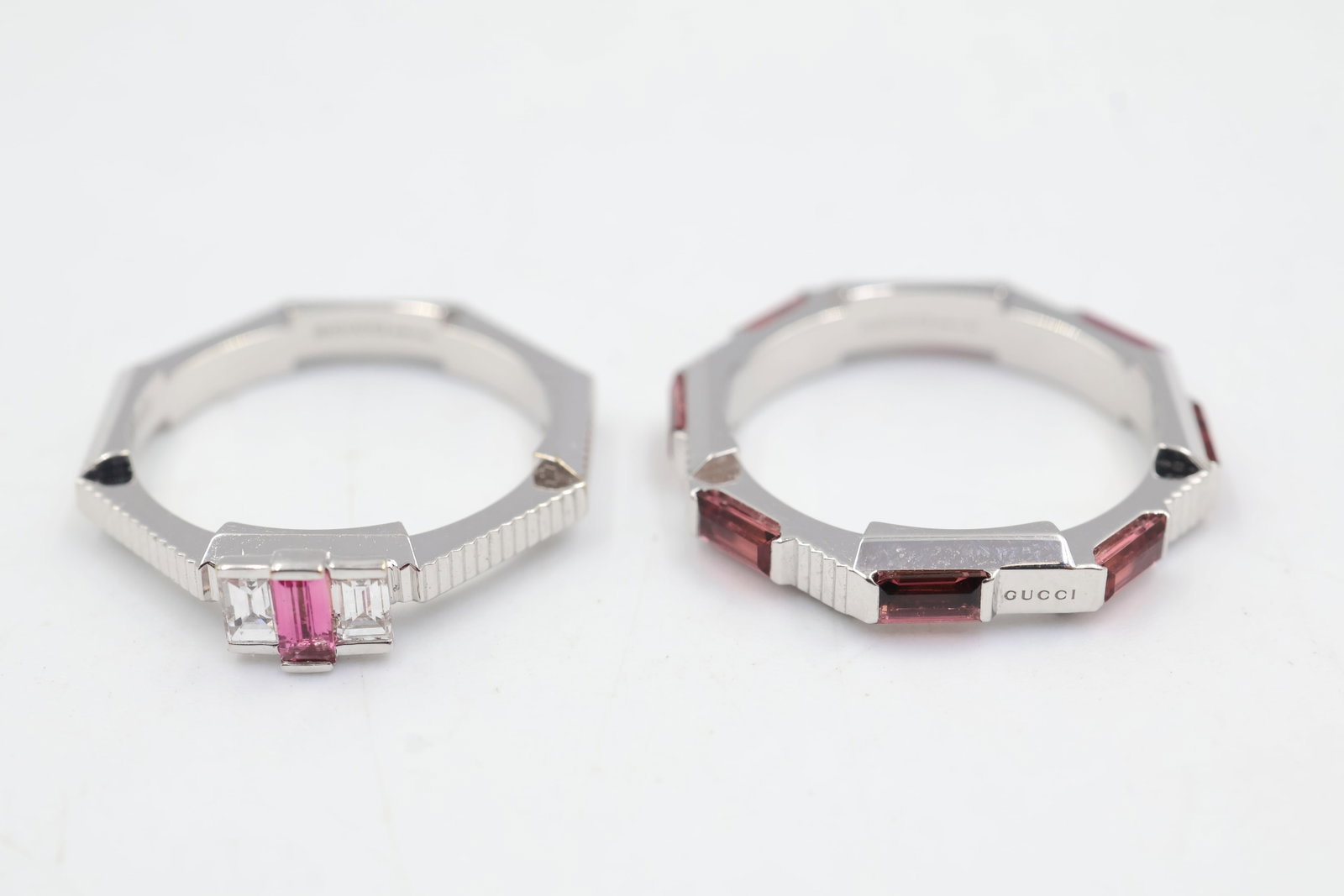 Gucci 18k White Gold & Pink Sapphire Ring Pair: Pair of Gucci rings crafted in 18K white gold and accented with vibrant pink sapphires. A sophisticated duo showcasing the House’s distinctive Italian design and contemporary luxury. Sizes 5.5/6.