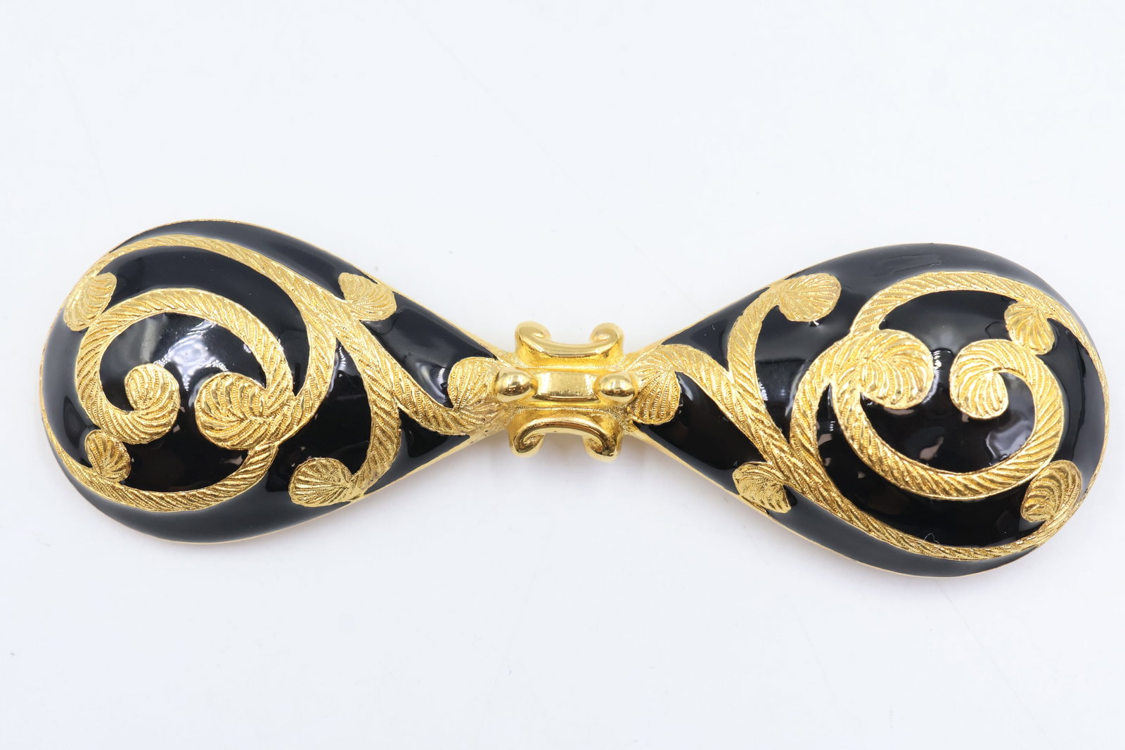 Dior Gold Tone & Black Enamel Brooch: Dior brooch featuring gold-tone metal and black enamel in an ornate Baroque-inspired design. A bold and collectible statement piece showcasing the House’s distinctive Parisian style.
