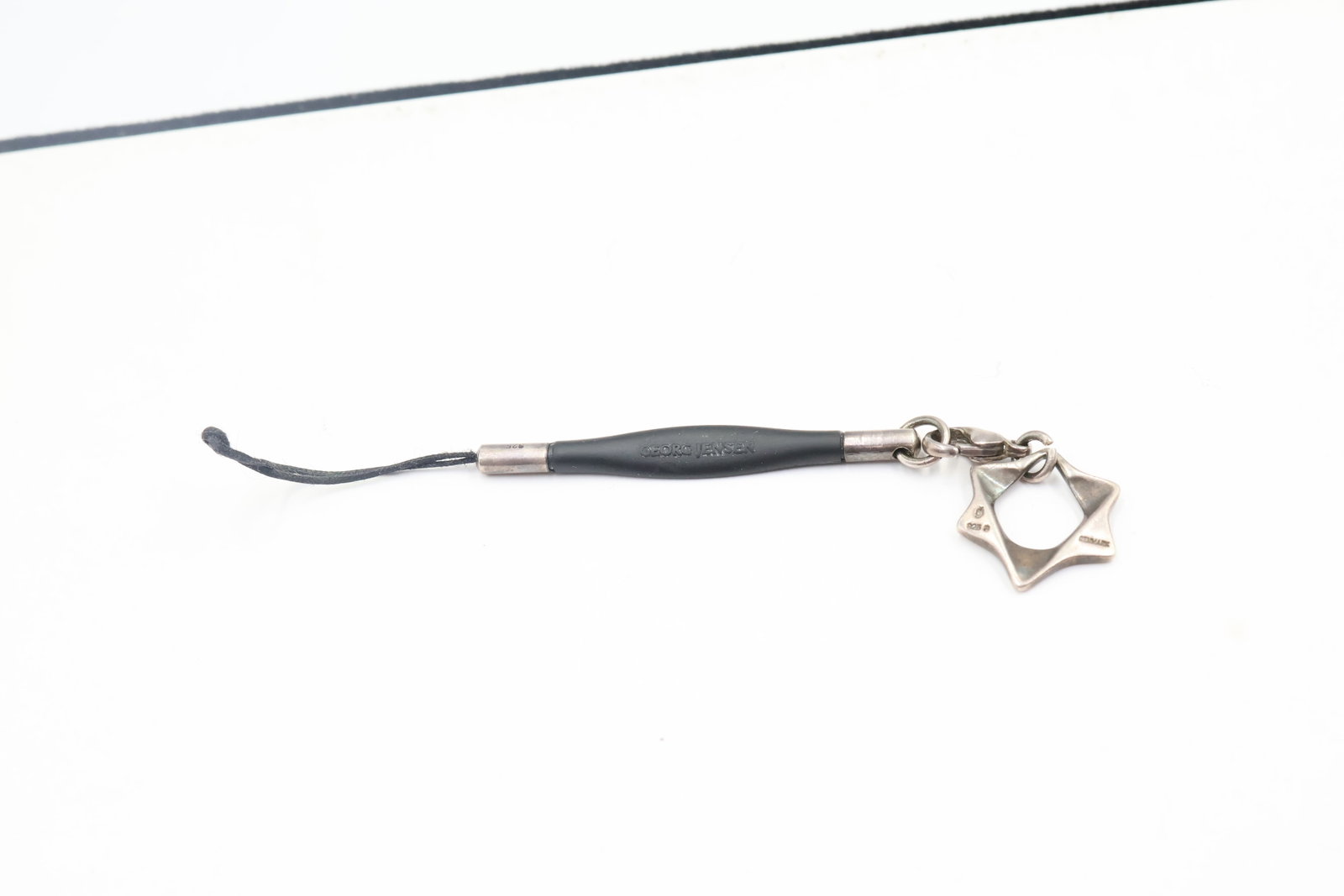 Georg Jensen Star of David Charm: Distinctive Georg Jensen Star of David charm crafted in sterling silver and presented on leather. A refined piece showcasing the Danish design house’s signature minimalist aesthetic and craftsmanshi