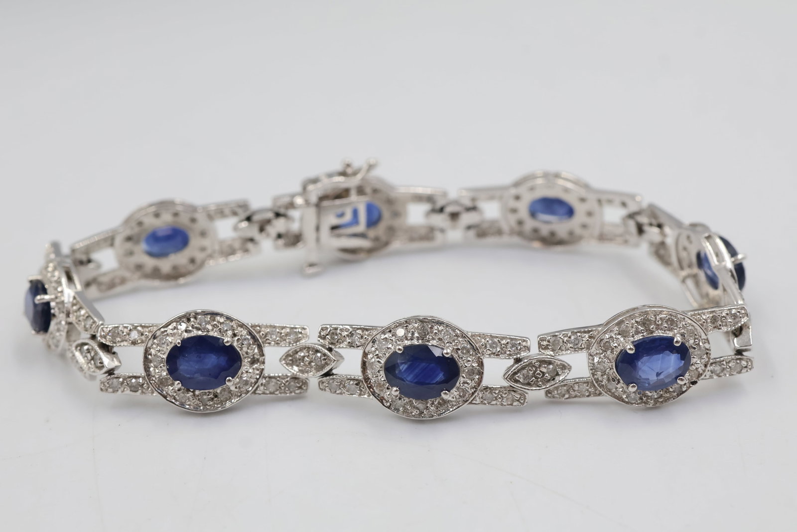 14kt Gold Sapphire & Diamond Bracelet: Art Deco-inspired 14K white gold bracelet featuring eight oval natural blue sapphires totaling approximately 11.49 carats, accented by 176 round brilliant-cut diamonds totaling approximately 2.46