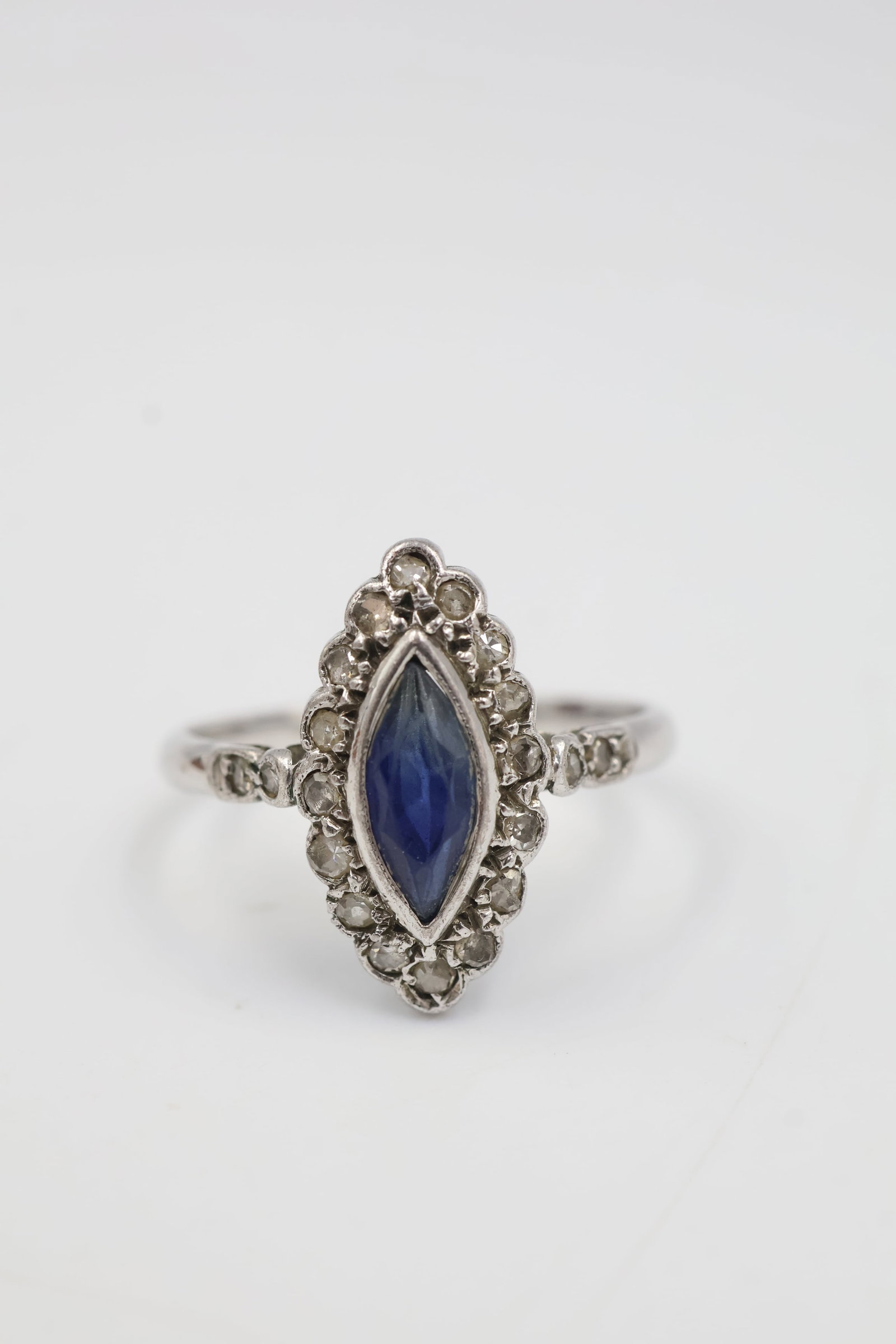 10k White Gold Sapphire & Diamond Ring: Elegant 10k white gold ring featuring a marquis sapphire accented by sparkling diamonds. Ring size: 7. Total weight: 2.0 grams.
