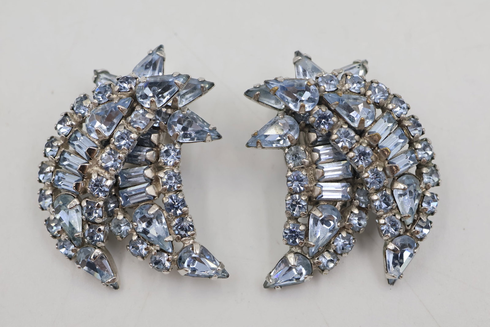 Sherman Shades Of Blue Clip On Earrings: Sherman clip-on earrings featuring faceted crystals in varying shades of blue, arranged in a sparkling dimensional design. A classic example of collectible Sherman jewellery.