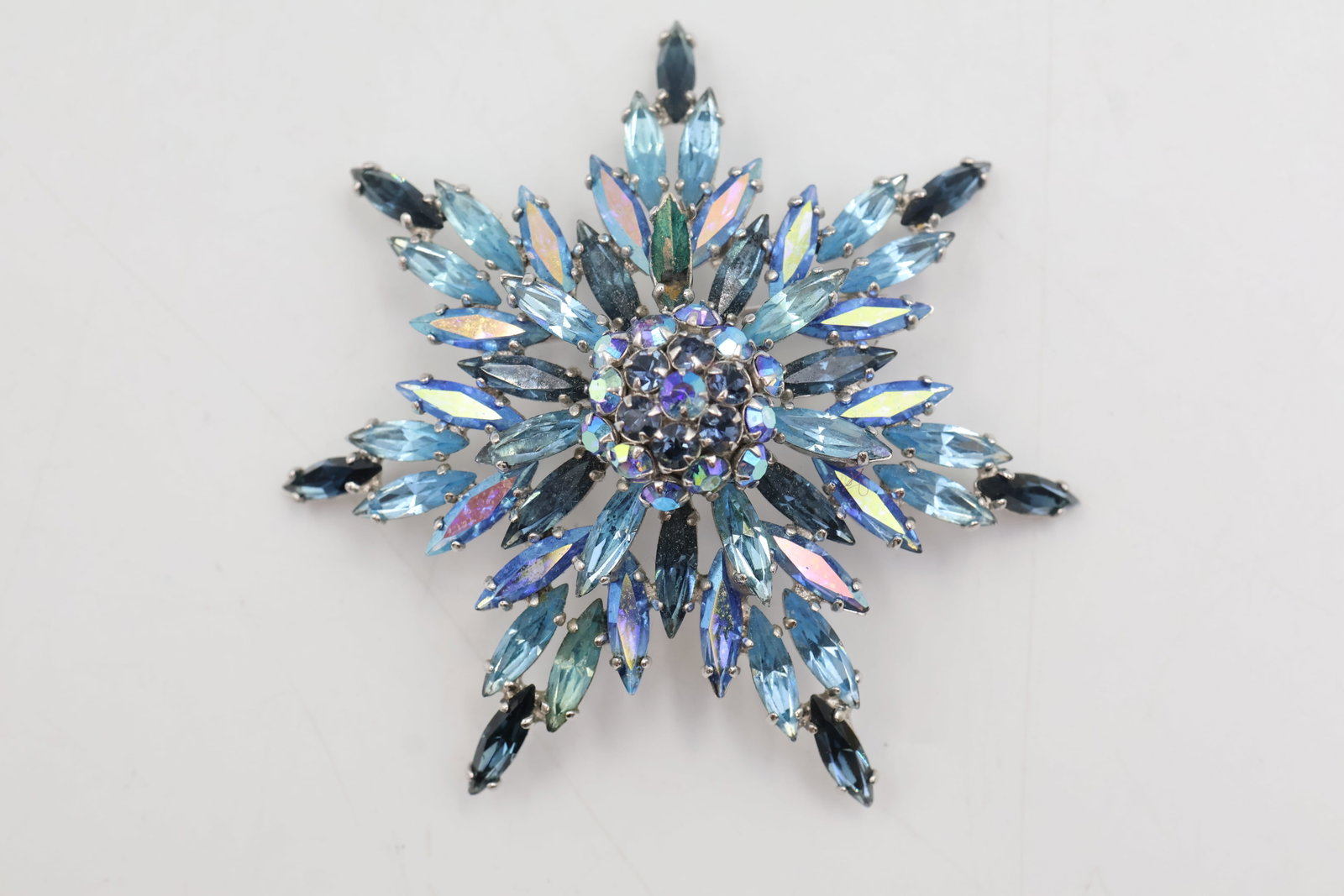 Sherman Shades Of Blue Brooch: Vintage Sherman brooch featuring faceted crystals in varying shades of blue, arranged in a striking dimensional design. A classic example of collectible Sherman jewellery.